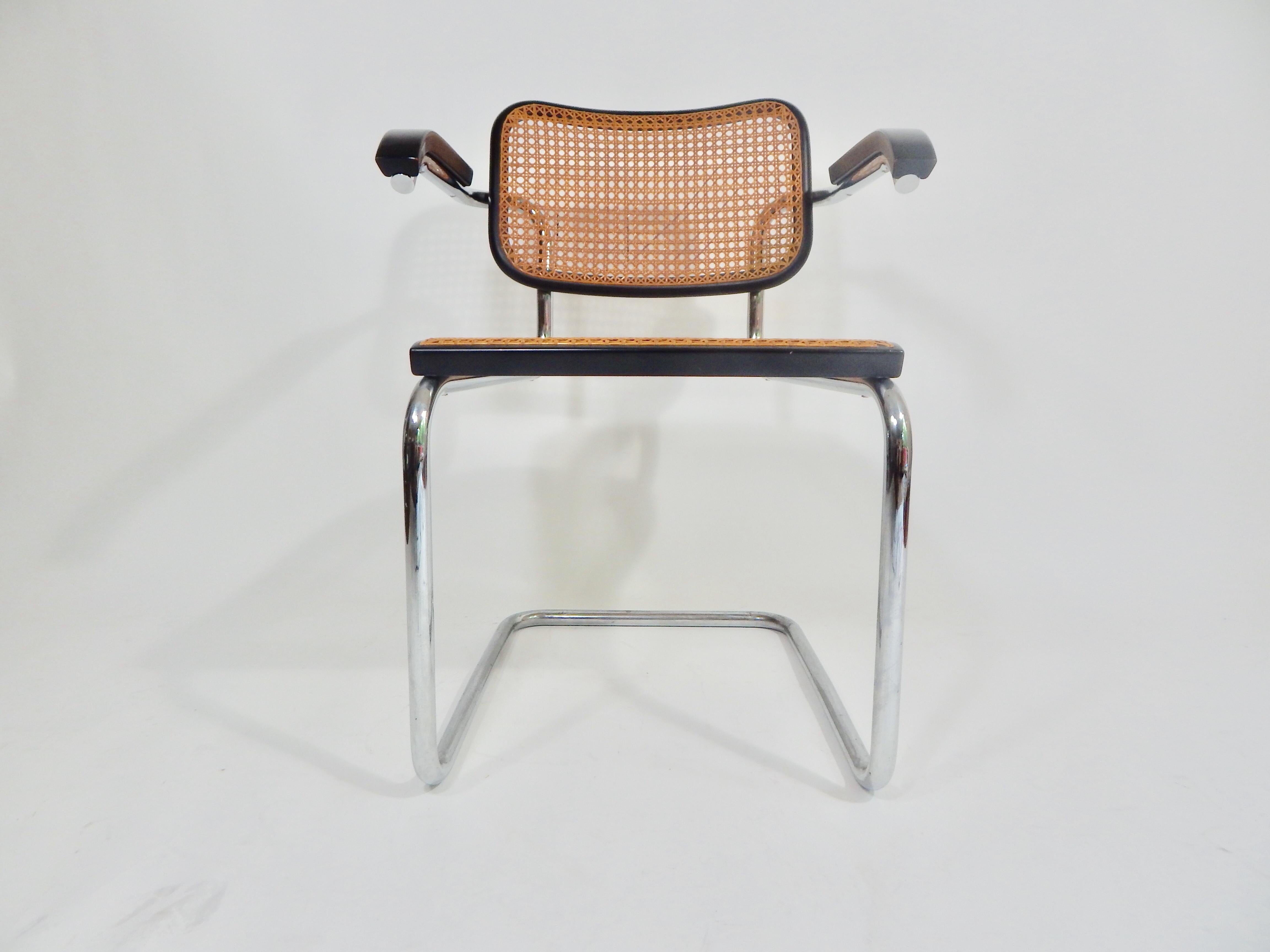 Black Marcel Breuer Cesca chairs manufactured by Knoll International and dated 1973. Black finished wood frames with cane seat and backrest Cane is intact. Measures: Arm height 27.25.