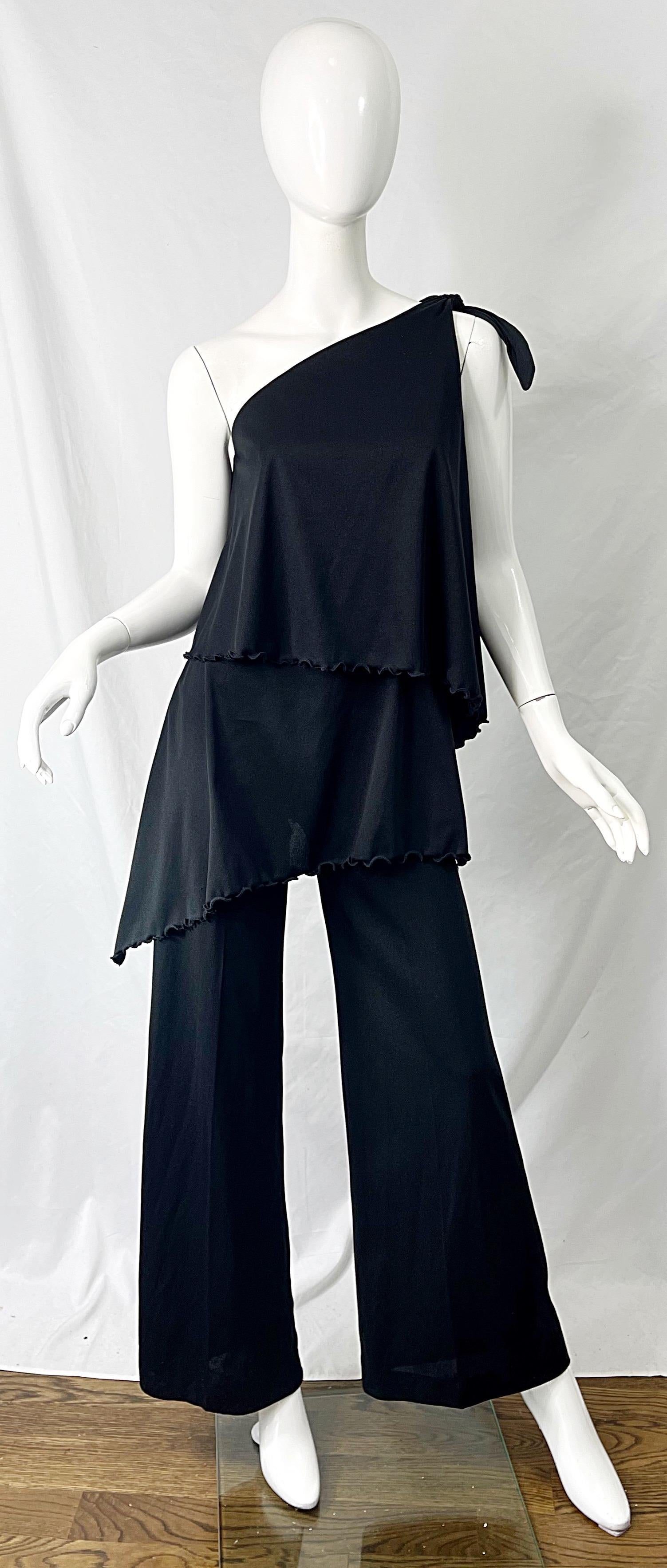 Chic 1970s one shoulder black jersey disco jumpsuit ! Features a tailored bodice with a tie at top left shoulder. Hidden zipper up the back with hook-and-eye closure. Flattering wide legs. Perfect for any day or evening event.
In great condition