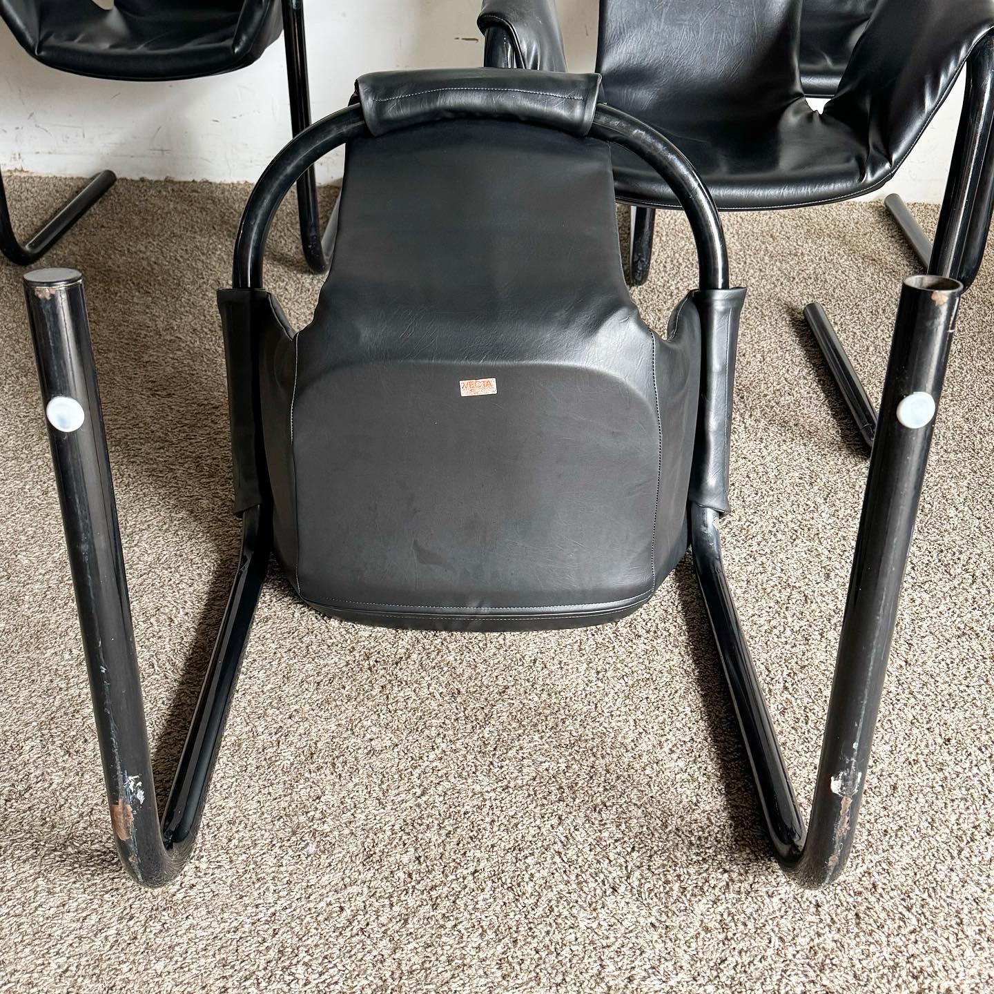 Embrace the retro flair of the 1970s with the Black Vinyl in Black Metal Zermatt Tubular Sling Chairs by Vecta. These iconic chairs feature a minimalist design with a black vinyl sling and tubular metal frame, perfect for adding a chic,