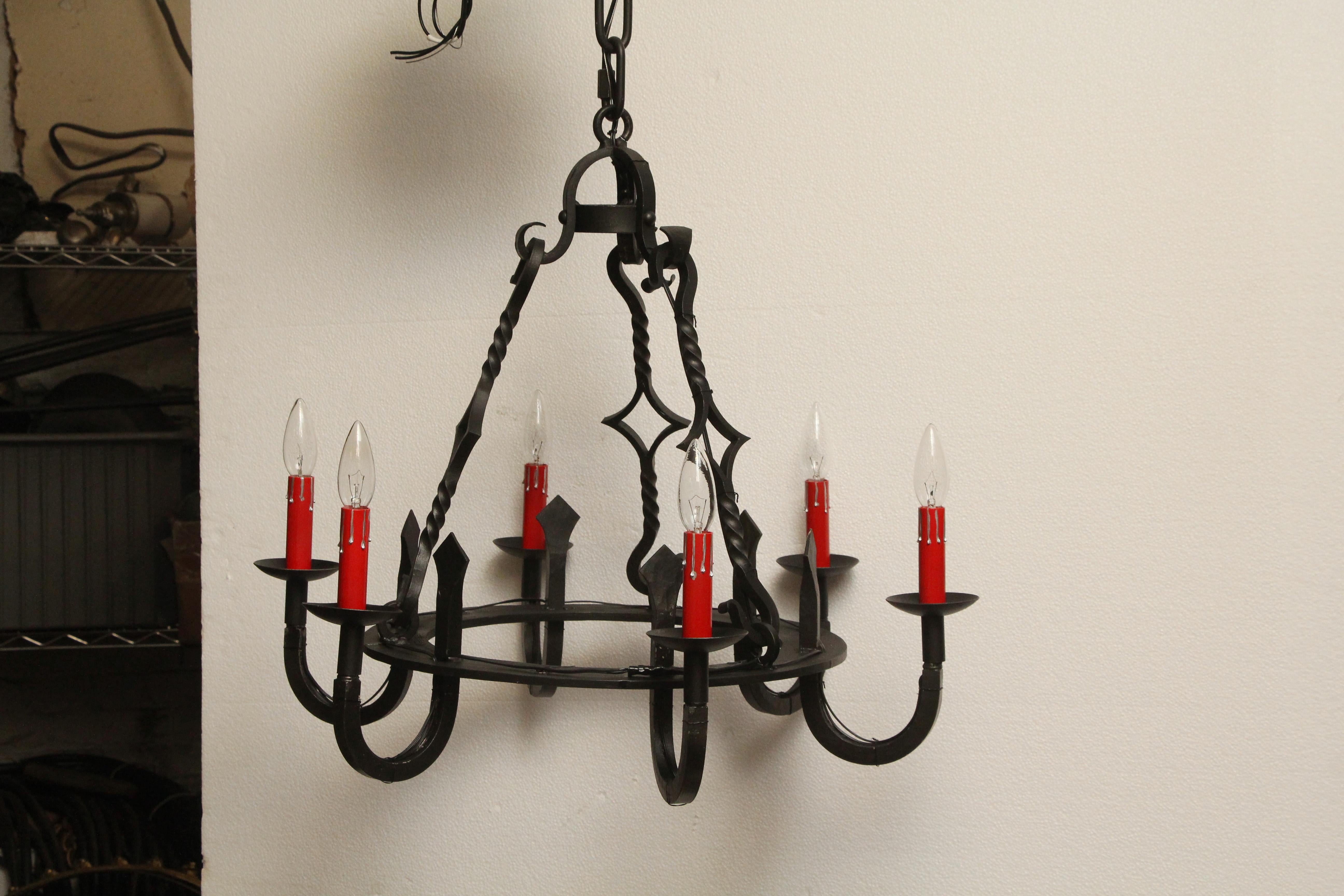 1970s wrought iron Gothic style black chandelier with six red candlestick arms. Cleaned and rewired. Please note, this item is located in our Los Angeles, CA location.