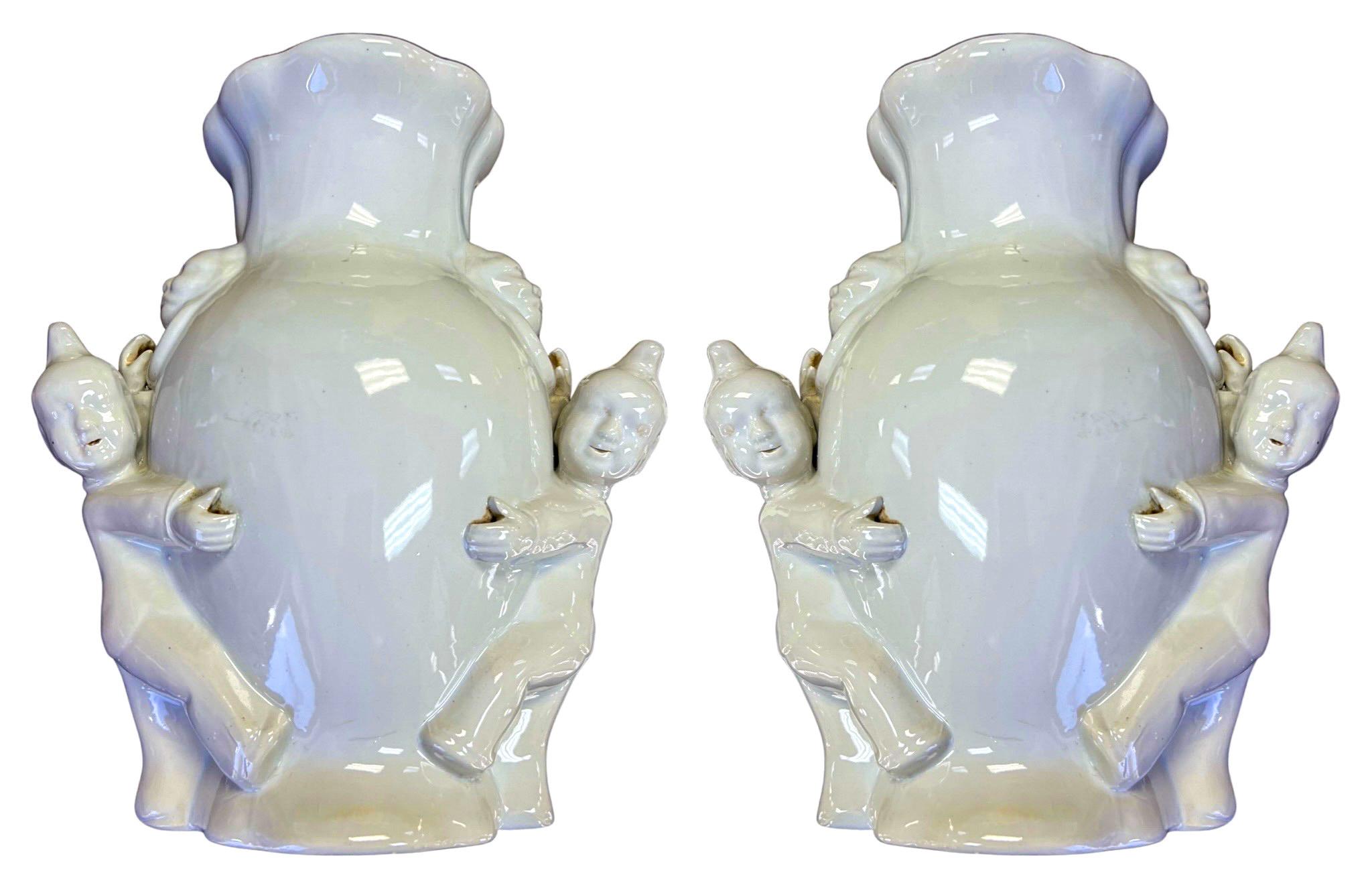 Si tratta di una bella coppia di tasche da parete in stile Blanc de Chine. Sono fantastici per incorniciare uno specchio! Ognuno di essi presenta una coppia di figure asiatiche che sostengono la forma dell'urna e le maniglie a forma di piuma. Sono