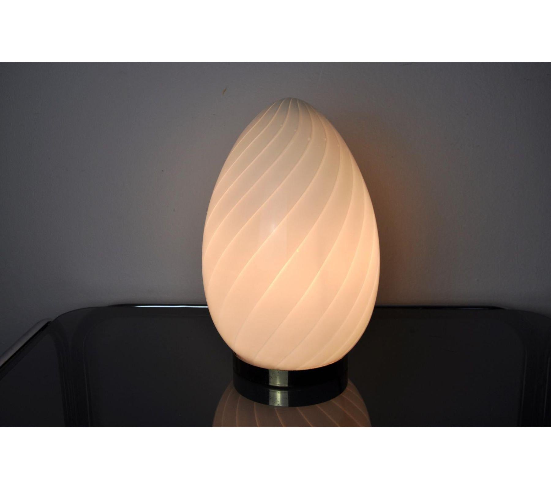 Very nice table lamp designated and produced in Spain in the 1970s. Egg-shaped blown glass, golden metal base. Unique object that will illuminate and bring a real design touch to your interior. Electricity verified. Time marks in accordance with the
