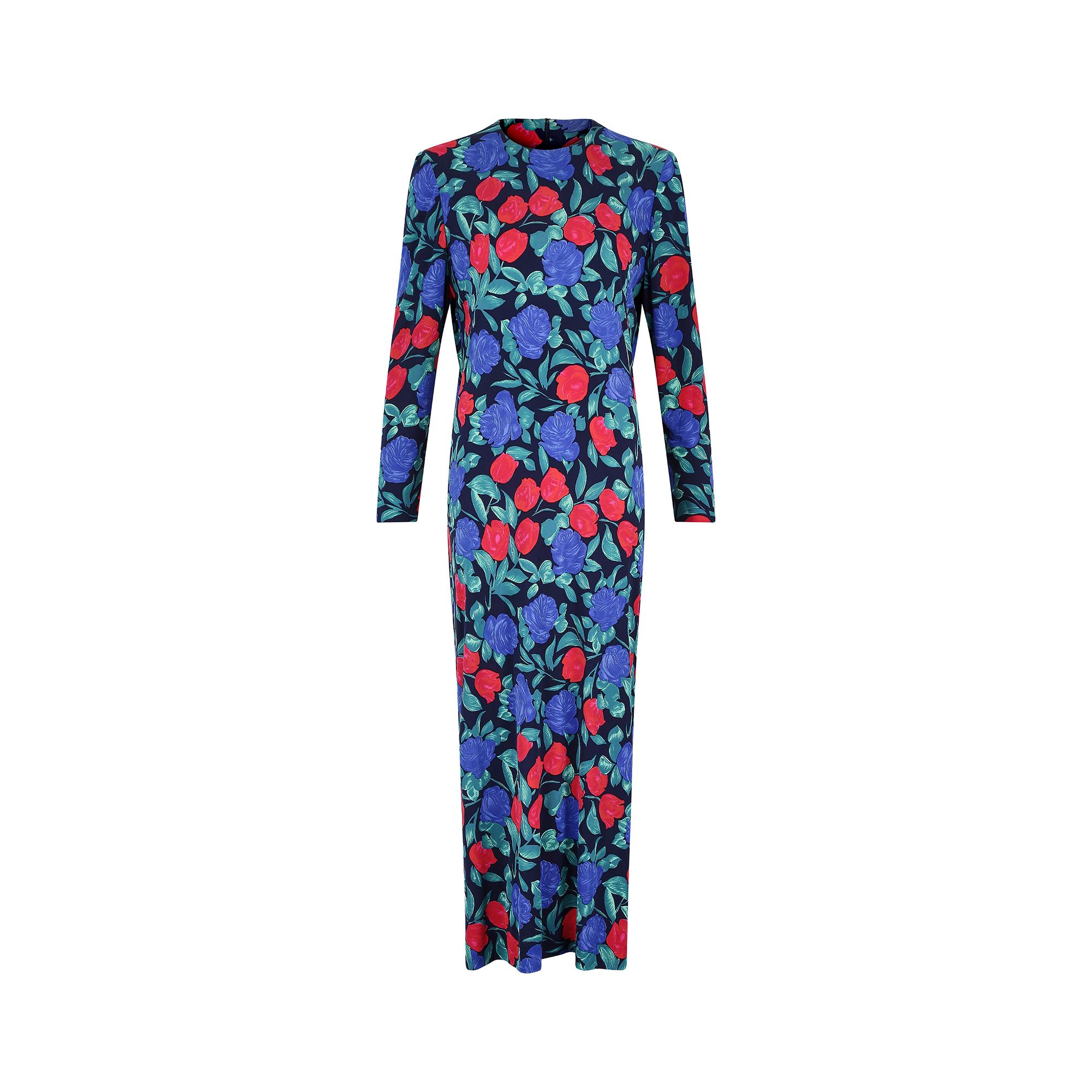 This late 1970s to early 1980s French couture silk jersey maxi dress has a beautiful blue and red rose print design against a darker blue background. It has a high, round neckline and is cut in a simple, shift-like shape to the ankles. It has long