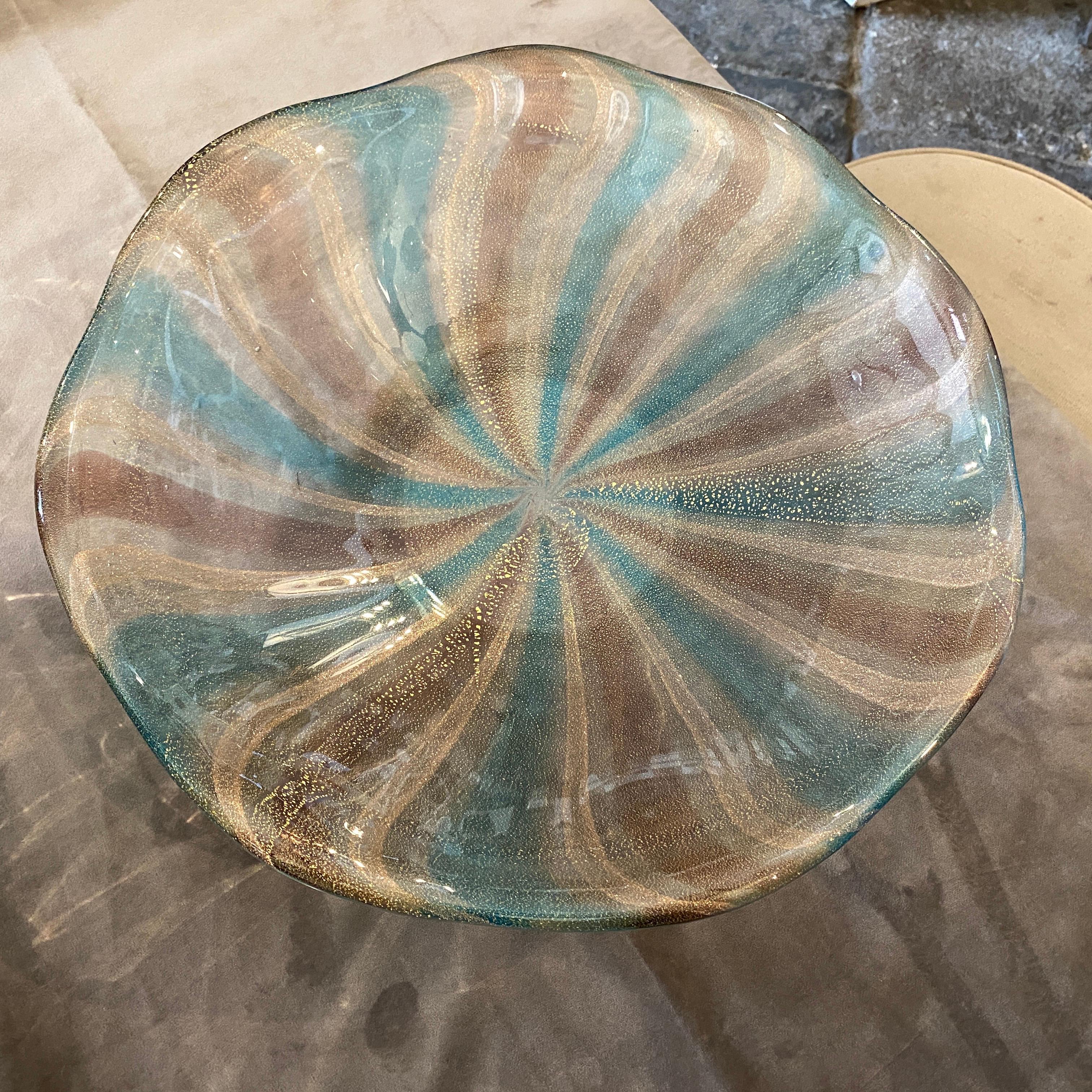 A large murano glass bowl manufactured in Venice in the manner of Fulvio Bianconi, it's in perfect conditions. This Centerpiece is a striking and luxurious decorative piece that showcases the exquisite craftsmanship and artistic flair characteristic