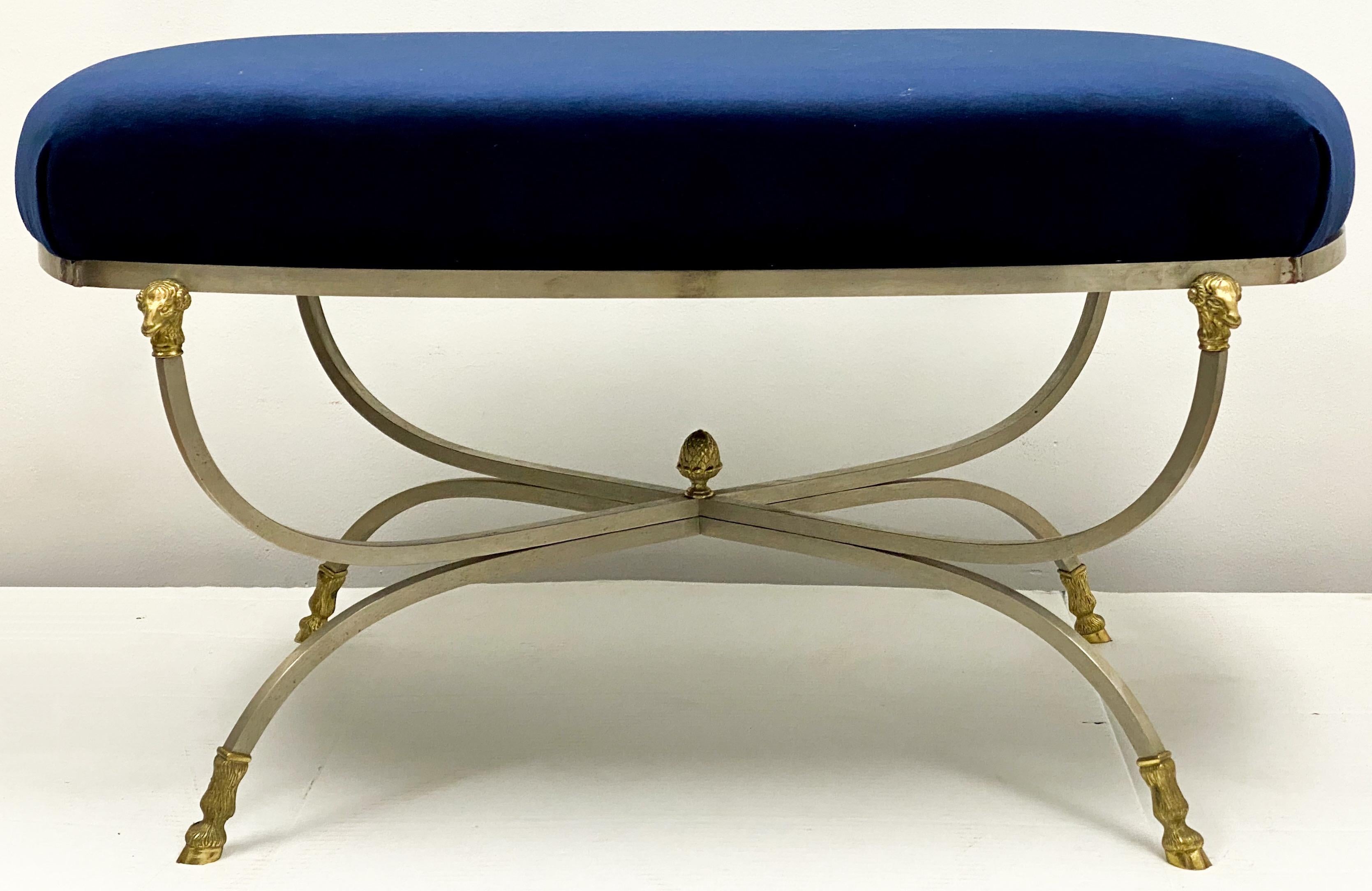 This is a 1970s Italian Maison Jansen style ottoman newly upholstered in a blue velvet. The frame is brushed steel with brass ram’s head and hoof appointments. It is in very good condition.