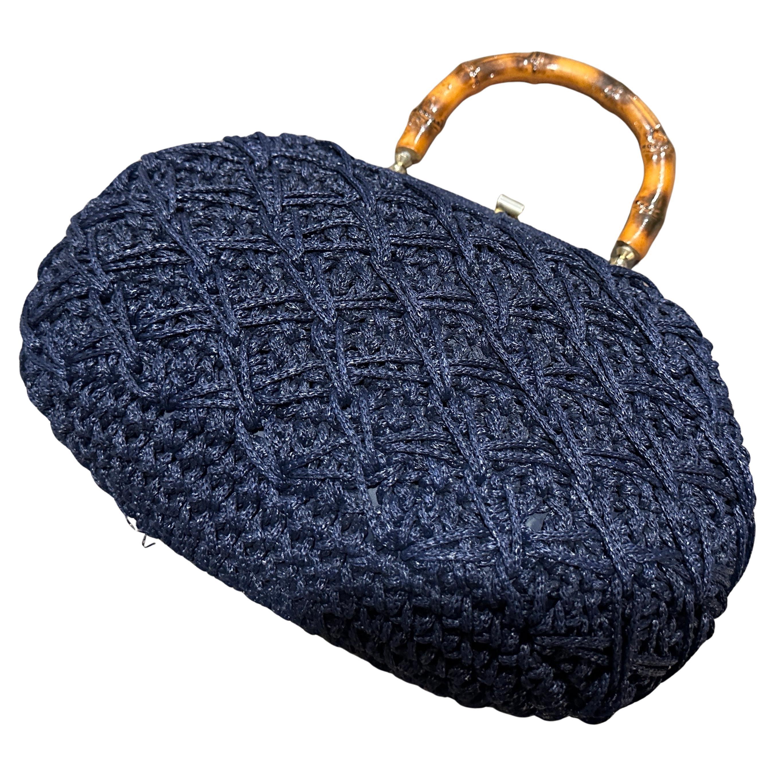 This vintage Italian handbag exudes a blend of rustic charm and refined craftsmanship, perfect for someone who appreciates artisanal details. The handbag features a richly textured navy blue woven body,  The intricate, lattice-like pattern on the