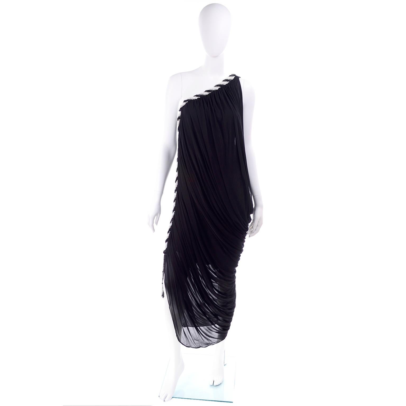This absolutely fabulous 1970's vintage dress was designed by Bob Mackie and it is truly incredible. The black jersey fabric of the dress is beautifully draped and it is trimmed with rows of black and white beads, clear beads, and rhinestones that