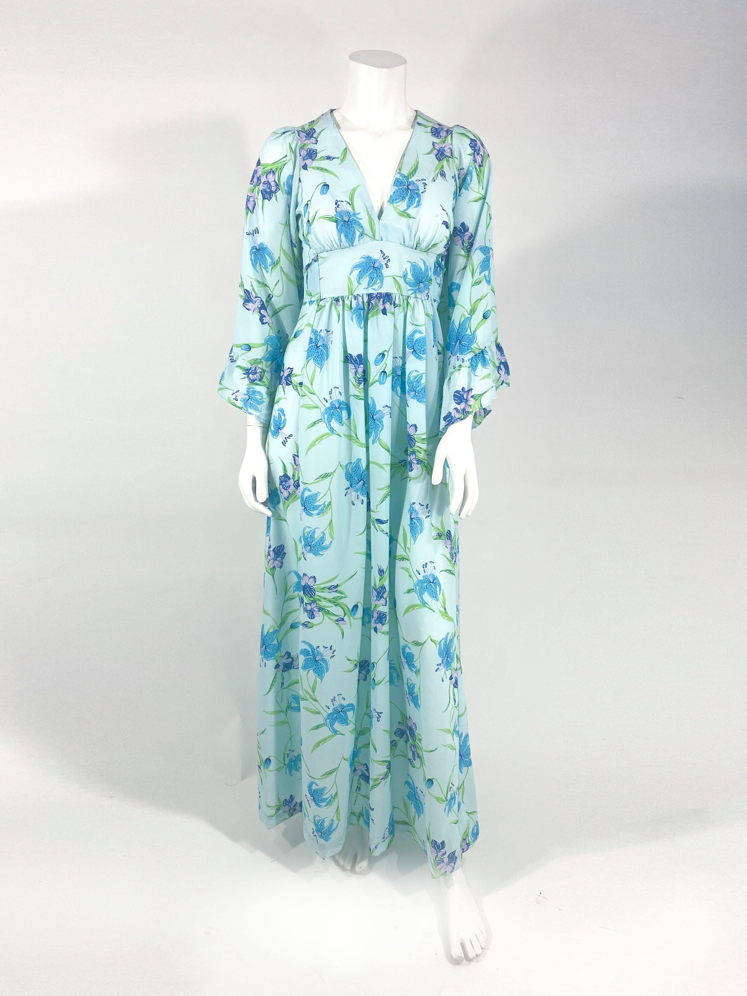 1970's bohemian aqua floral printed full length dress with a plunging neckline, full ruffled bell sleeves, an applied empire-waist sash that ties over the back zipper closure.