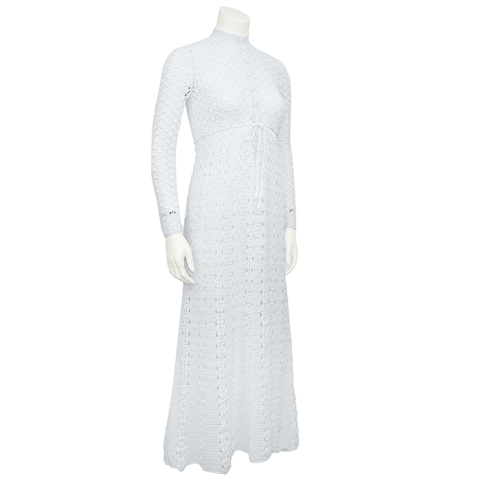 Beautiful bohemian handmade label-less  white cotton crochet dress from the 1970s. Mock neck with long sleeves, buttons down centre front and pull through tie at the waist. Skirt skims the body and can be a midi or maxi dress depending on your