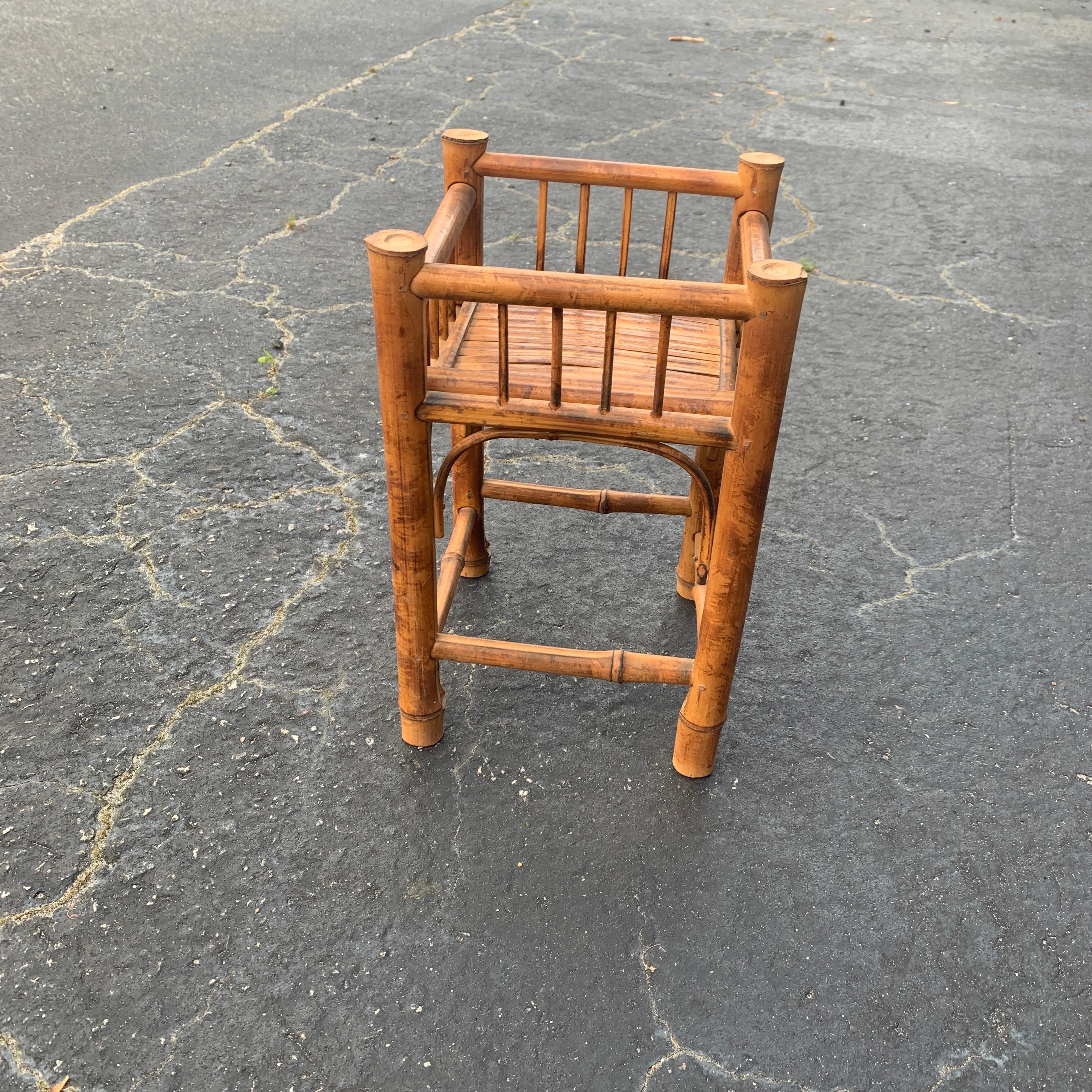 1970s Boho chic handcrafted rattan planter in great shape. The planter of your choosing rests inside of the stand. This helps to protect it from being knocked over and breaking. The depression measures 3 inches deep by 7 inches wide and long.