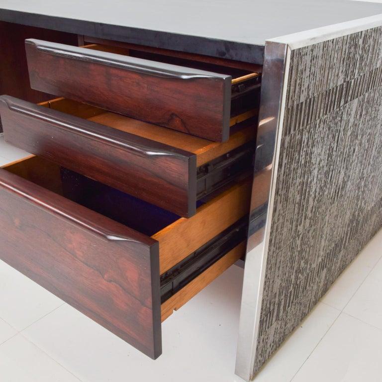 1970s Executive Desk by Billy Joe McCarroll and David Gillespie Forms Surfaces Inc Santa Barbara, California. 
Very elegant desk brutalist pattern gray tones. 
Black formica top with steel coverings on edges. 
Rosewood drawers with sculptural built