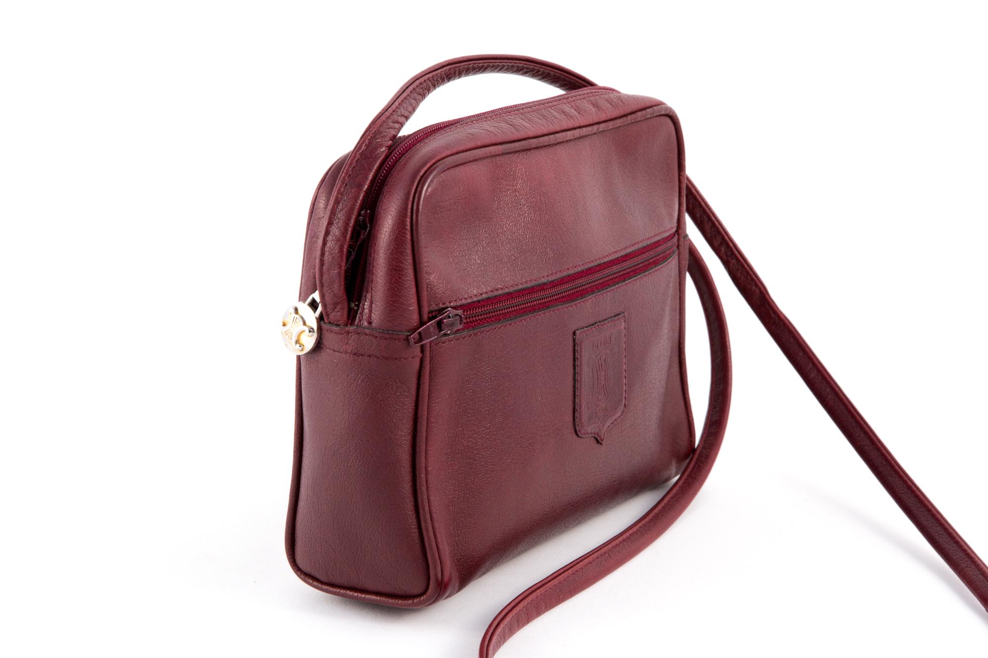 1970s Celine bordeaux leather shoulder bag featuring  a top zip fastening, a logo gold-tone zip puller, a leather front logo embossed, long shoulder strap, a front zip pocket, an inside compartment, an inside logo stamp.
Width: 7.8in. (20cm)
Height: