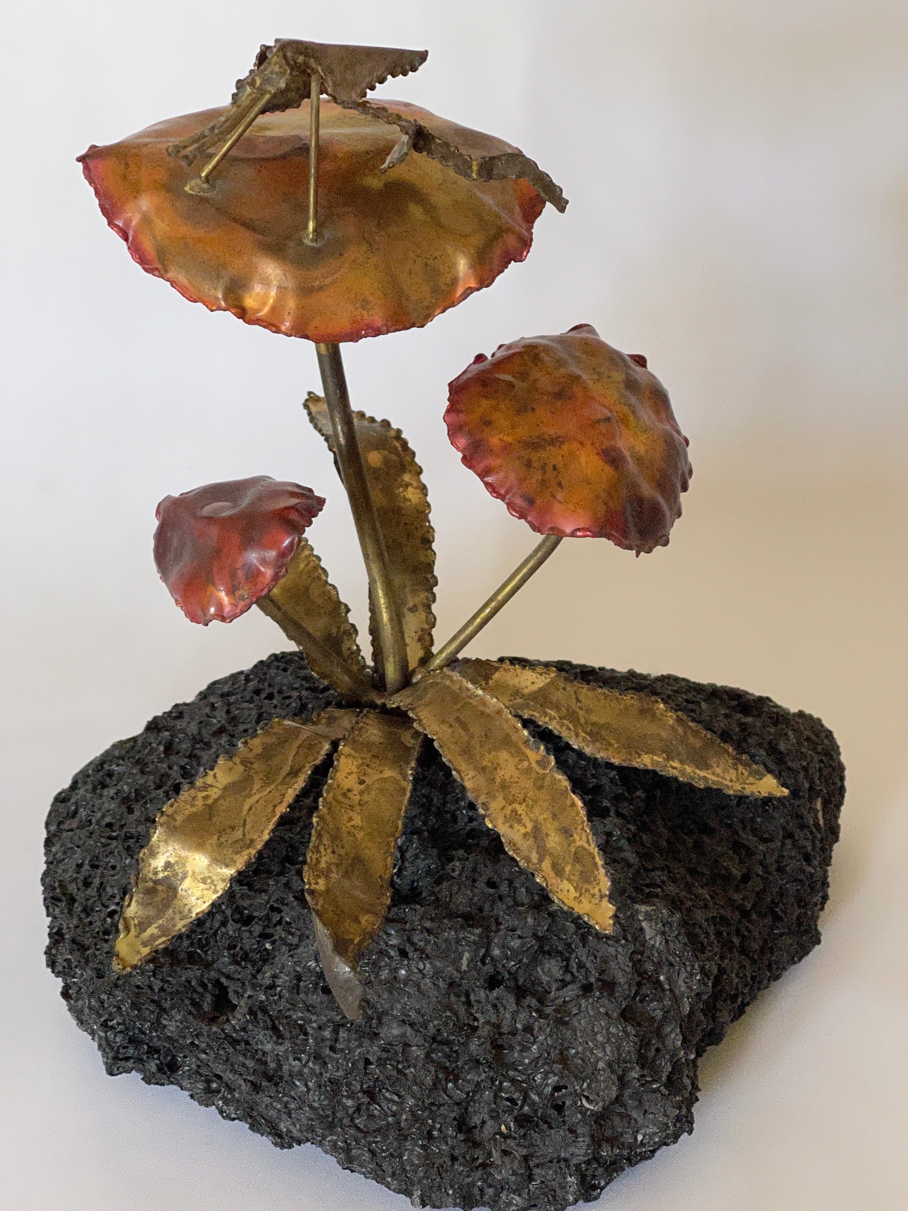 Whimsical 1970's torch cut patinated brass grasshopper on copper washed brass mushroom sculpture., mounted on lava stone base.