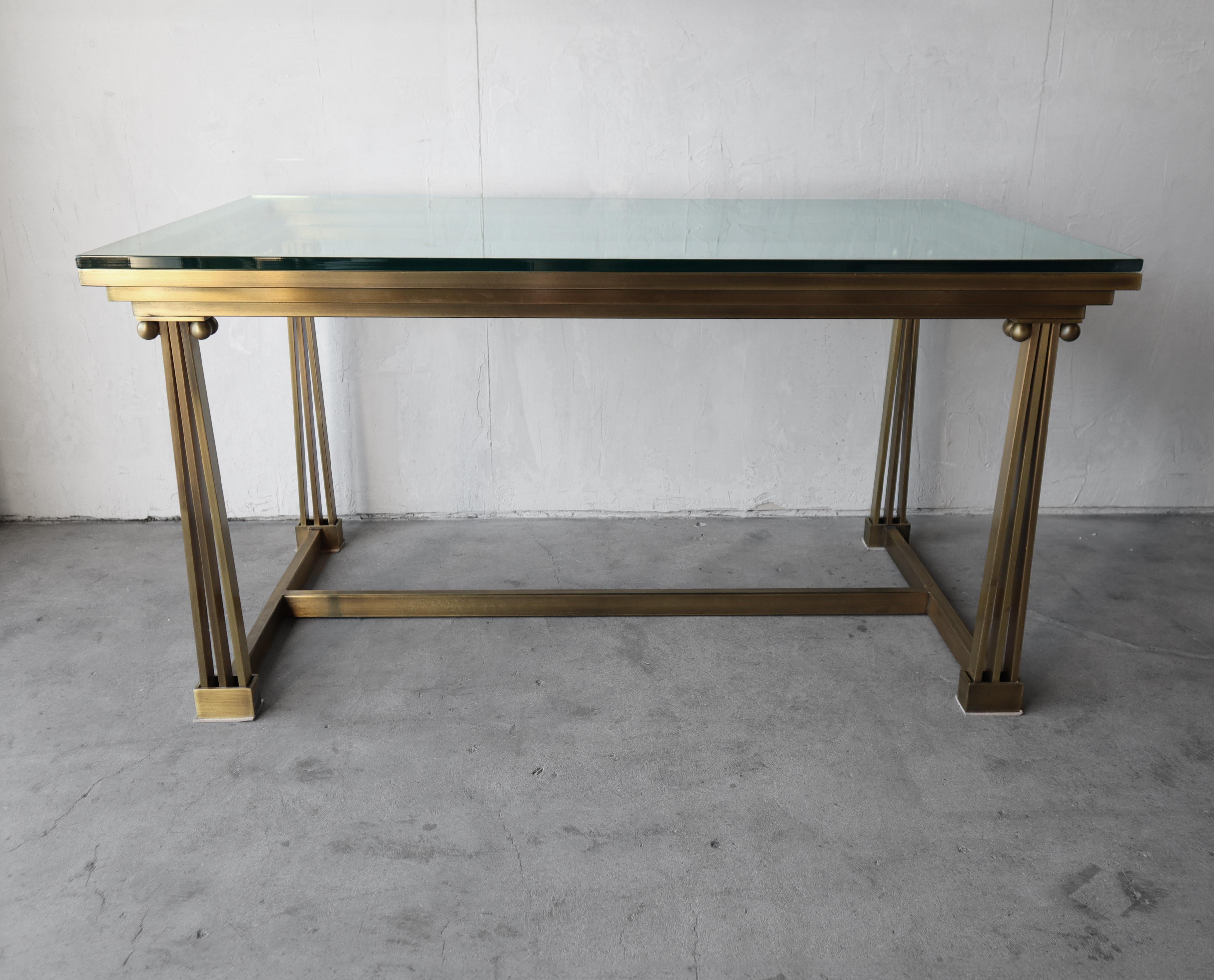 Una preciosa mesa Mastercraft de latón. La base le da un aire art déco muy neoclásico.  Sería la mesa de escritorio o de comedor perfecta para espacios reducidos.

La base está en buen estado, con una pátina y un desgaste mínimos propios de la edad.