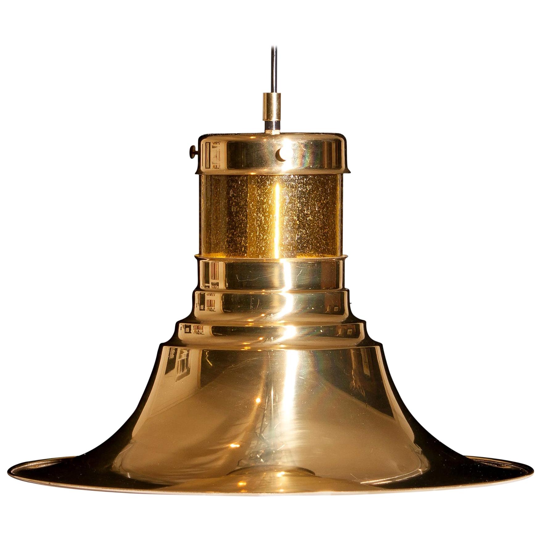 Magnificent pendant designed by Börje Claes for Norellet, Sweden.
This lamp is made of brass with an enamel white inside and a yellow cylinder of glass.
The beautiful shape makes that it gives a wonderful shining.
Period: 1970s.
Dimensions: H 32