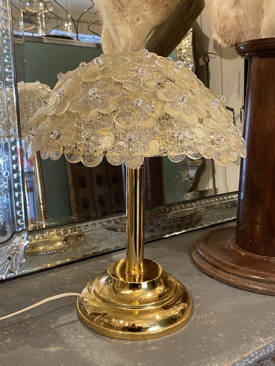 Stunning Italian table lamp from the 1970s, in brass.

The shade is comprised of beautiful charming murano glass flowers, which cast a gorgeous light.

  