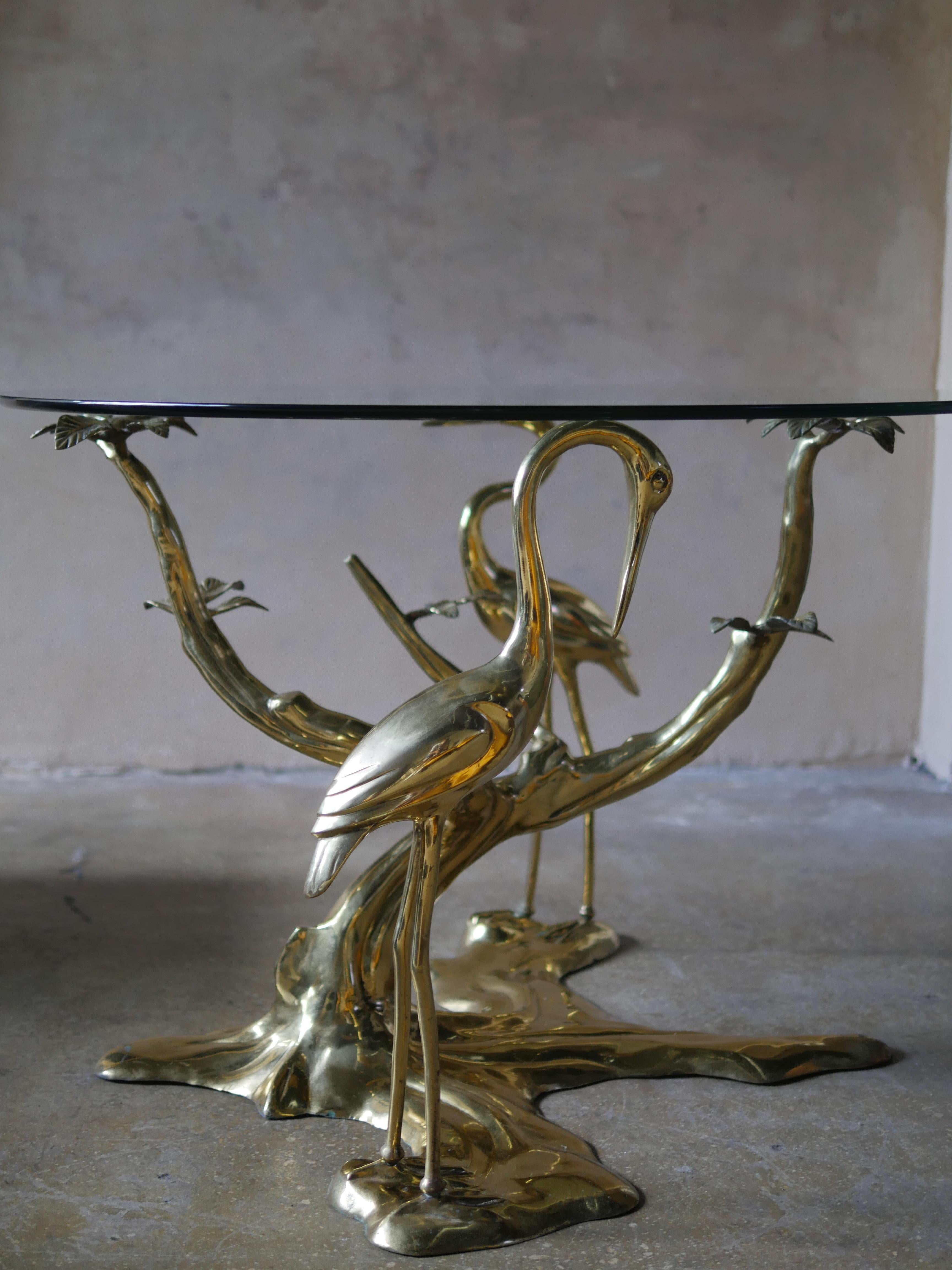 Elegant 1970s brass crane and bonsai tree entry table by designer Willy Daro. A 42” round glass top rests on the beautifully sculpted base, making this table a unique work of art. Willy Daro, a French postwar artist known for his botanical and