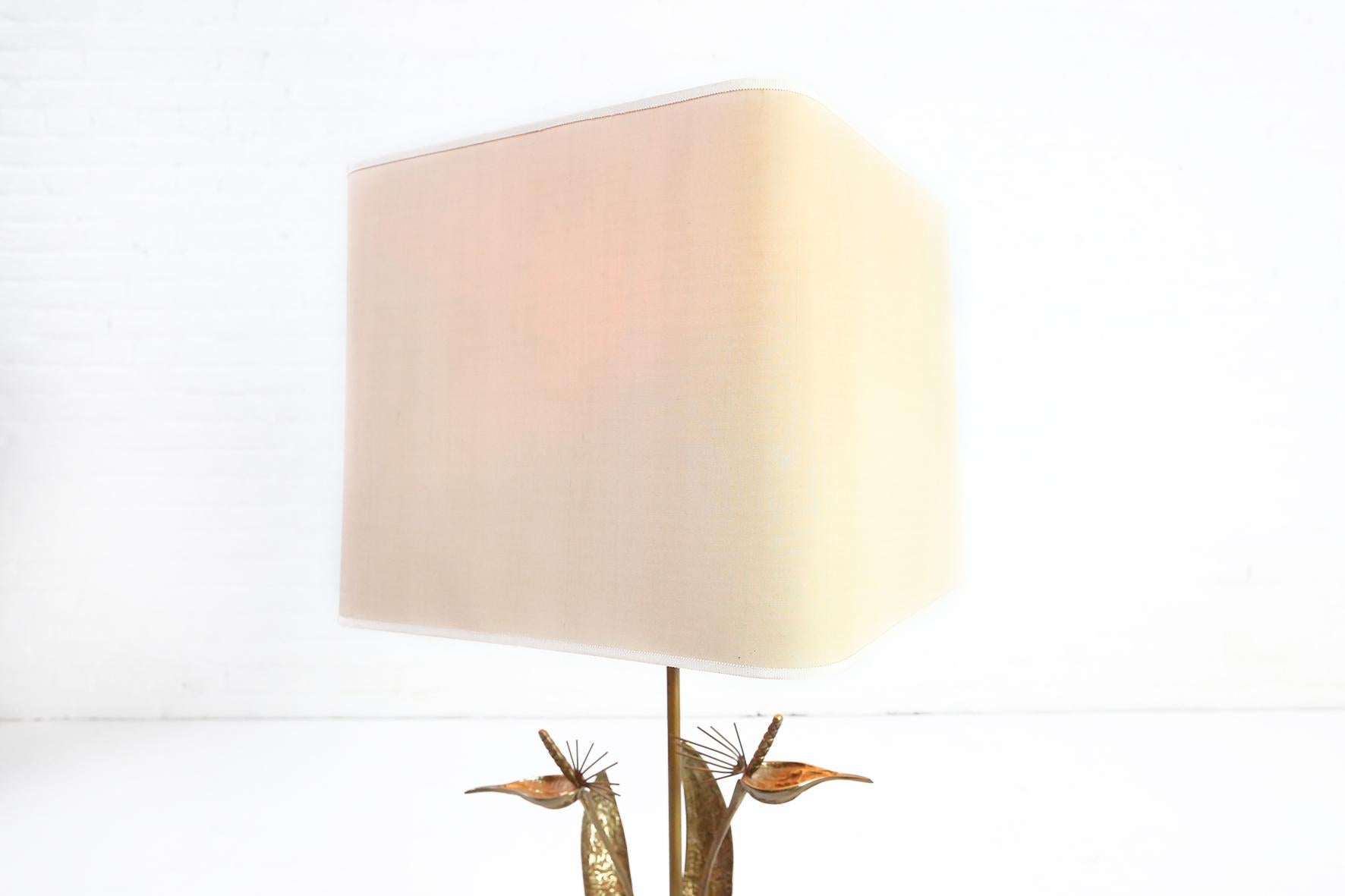 This high quality brass table lamp in Maison Charles style can be dated in the 1970s.
It is a stylish table lamp in great condition with its original shade.
 