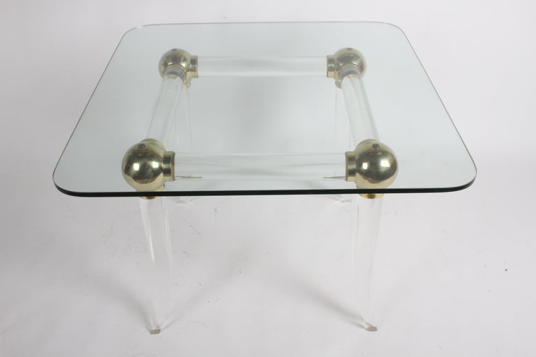 Fantastic Karl Springer style Hollywood Regency 1970s brass, Lucite and glass top game table with four large brass balls connecting the round Lucite supports and sitting on Lucite saber form legs. From one owner estate, table originally had four
