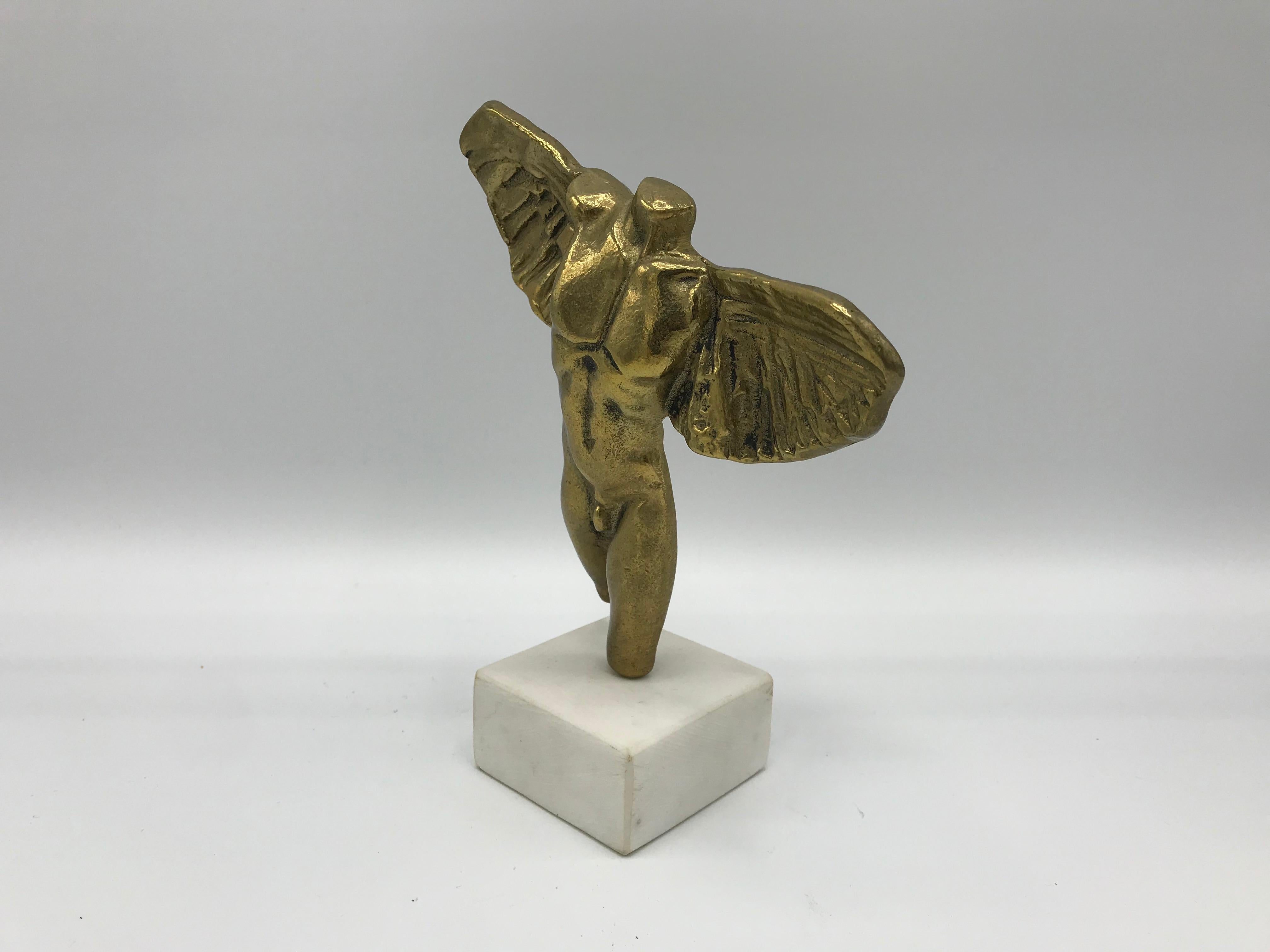 Listed is a gorgeous, 1970s solid-brass male nude angel sculpture on a white solid-marble base. Signed, though illegible.