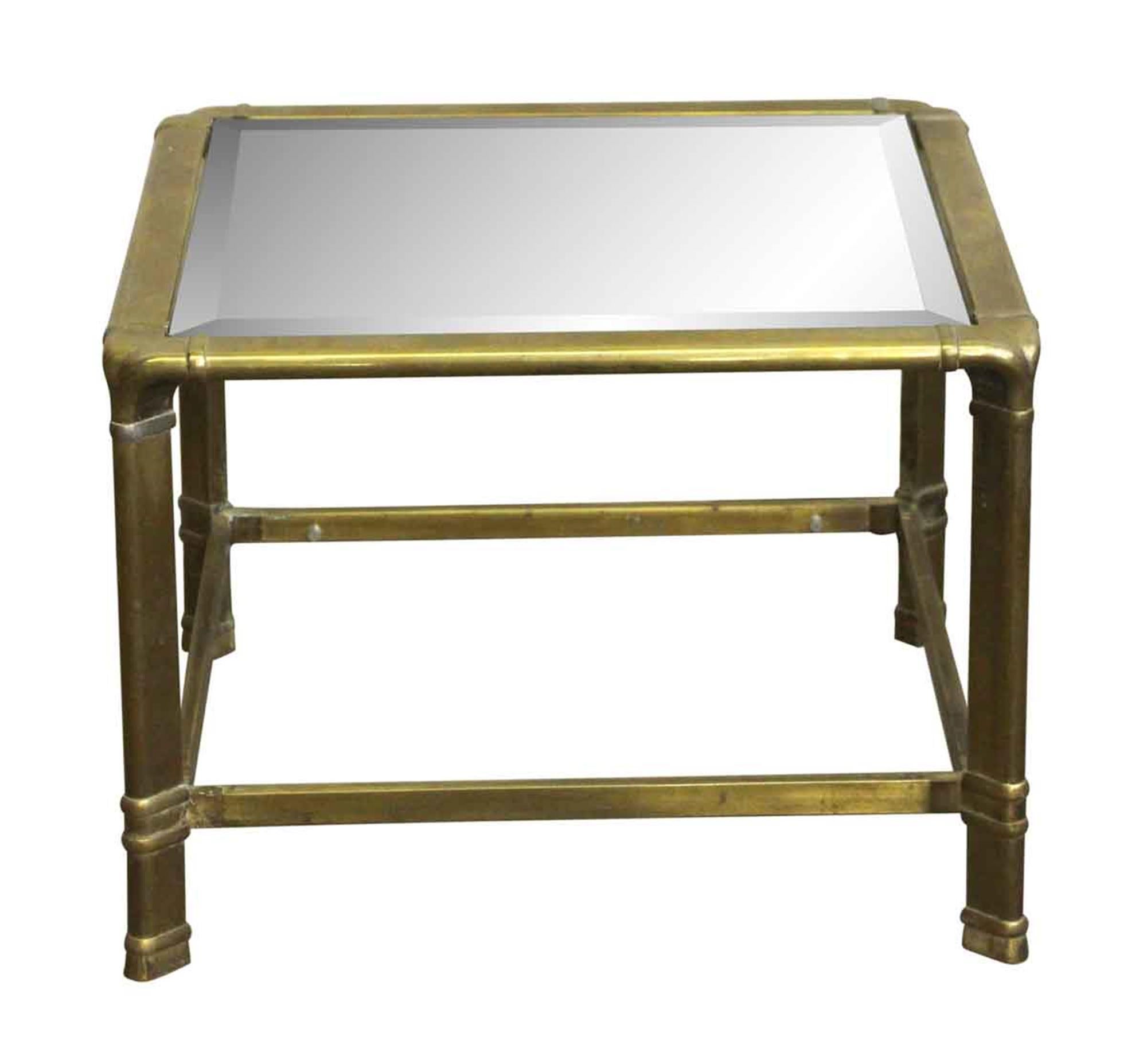 1970s brass frame end table with beveled glass done in a Mid-Century Modern style. The pin to secure the glass on the bottom needs work, therefore the bottom glass is not pictured. There is a chip in the bottom glass piece as well. This can be seen