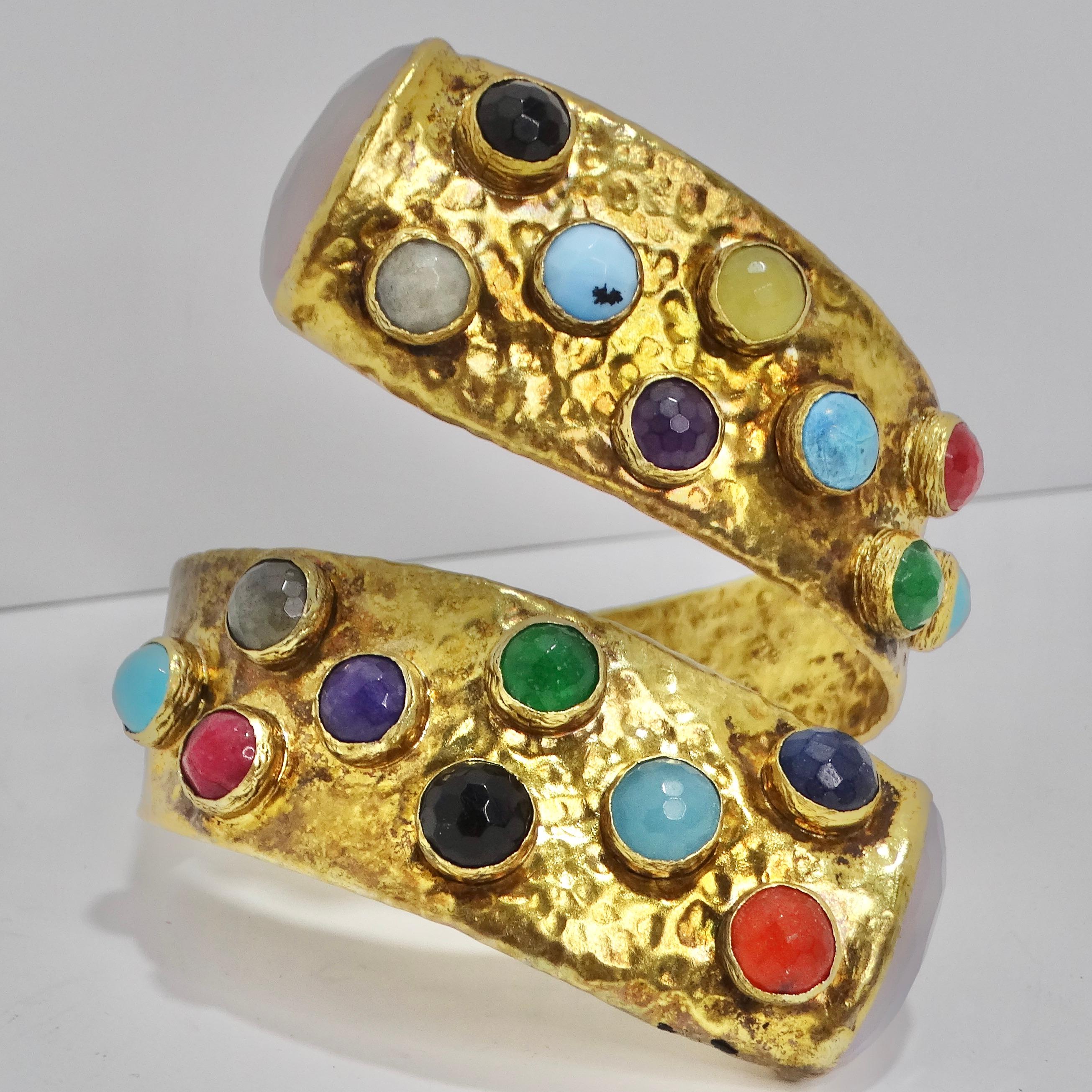 Elevate your style with this 1970s Brass Multicolor Gemstone Cuff Bracelet. This incredible cuff boasts an abstract, wraparound motif crafted from textured brass and adorned with a striking array of multicolor gemstones. With its eye-catching design