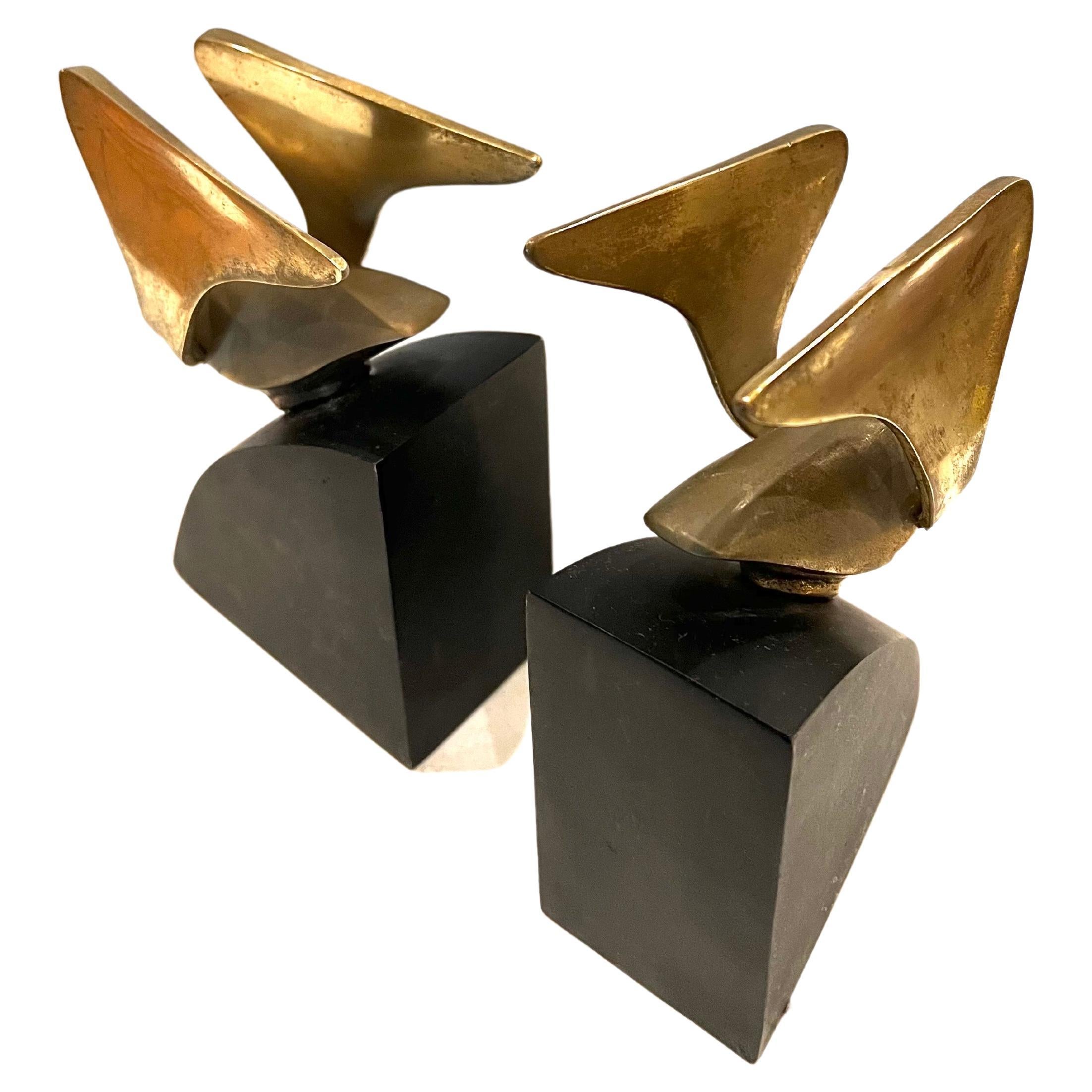 Nice pair of patinated brass flying birds bookends sitting on black enameled metal base.
