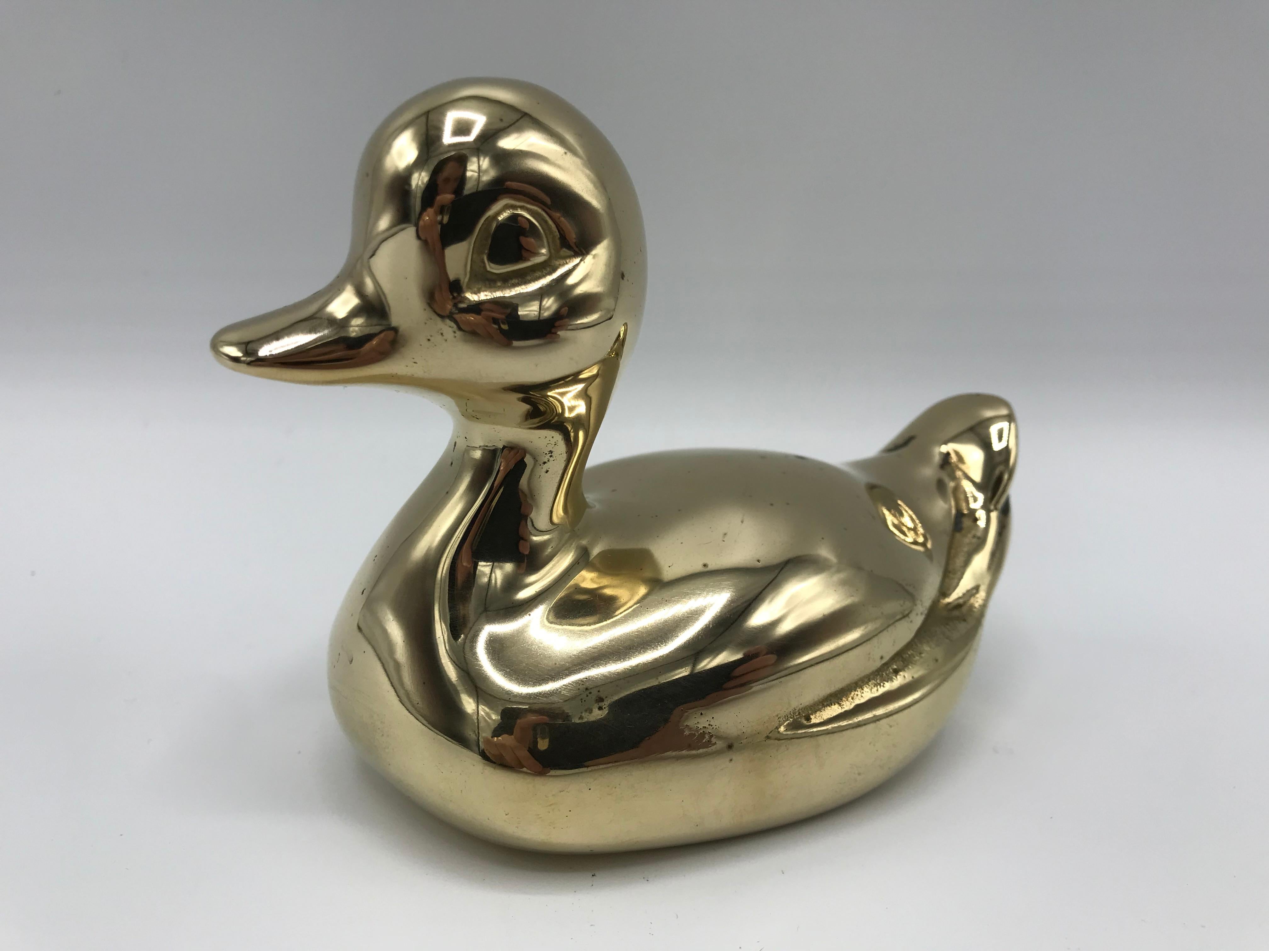 Offered is a unique and nostalgic, 1970s polished-brass rubber duck sculpture. The piece is a replicated, miniature scale of a vintage children's rubber duck toy.