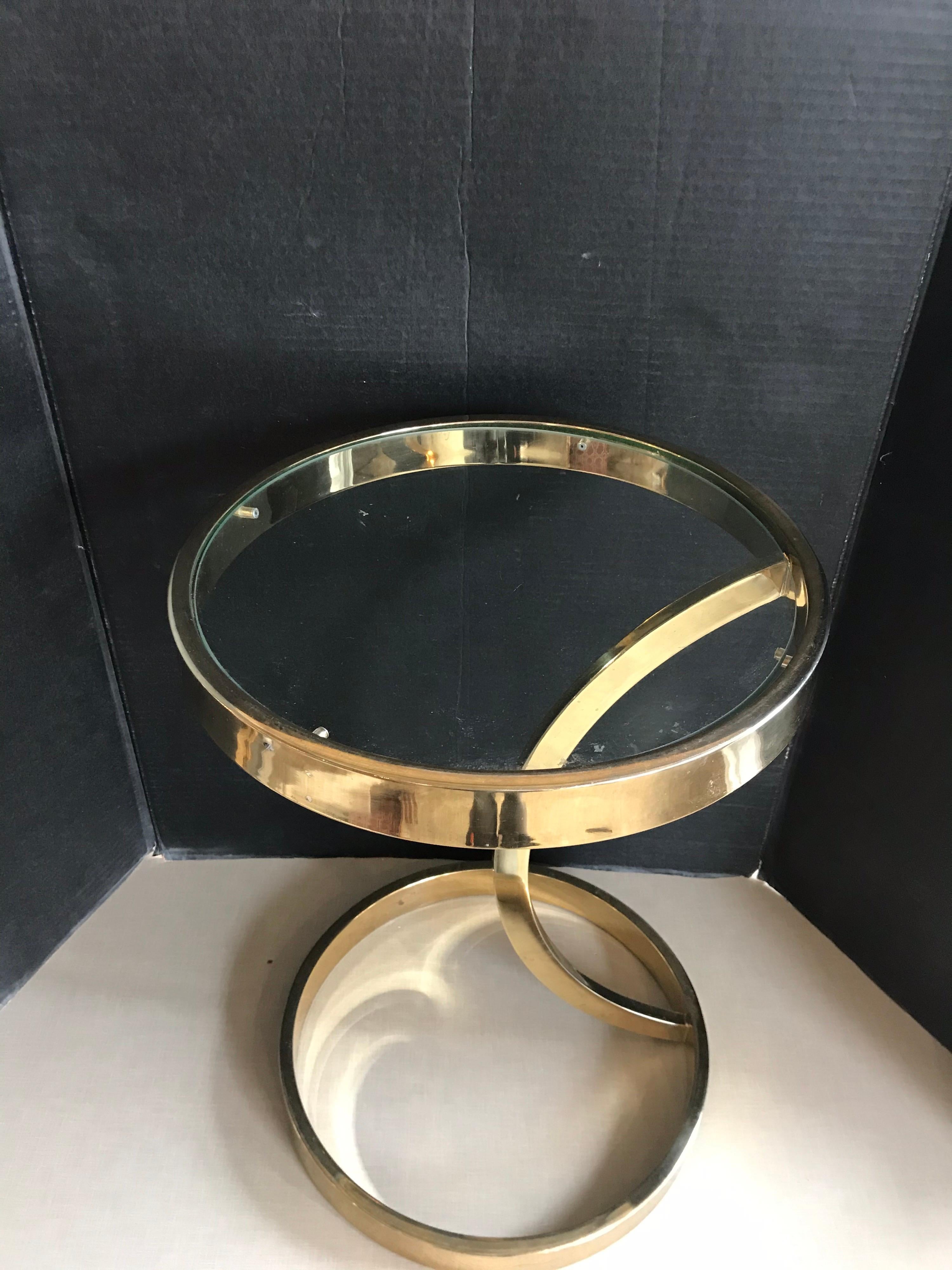 This is a small brass side table with glass top in the style of Milo Baughman from 1970s.