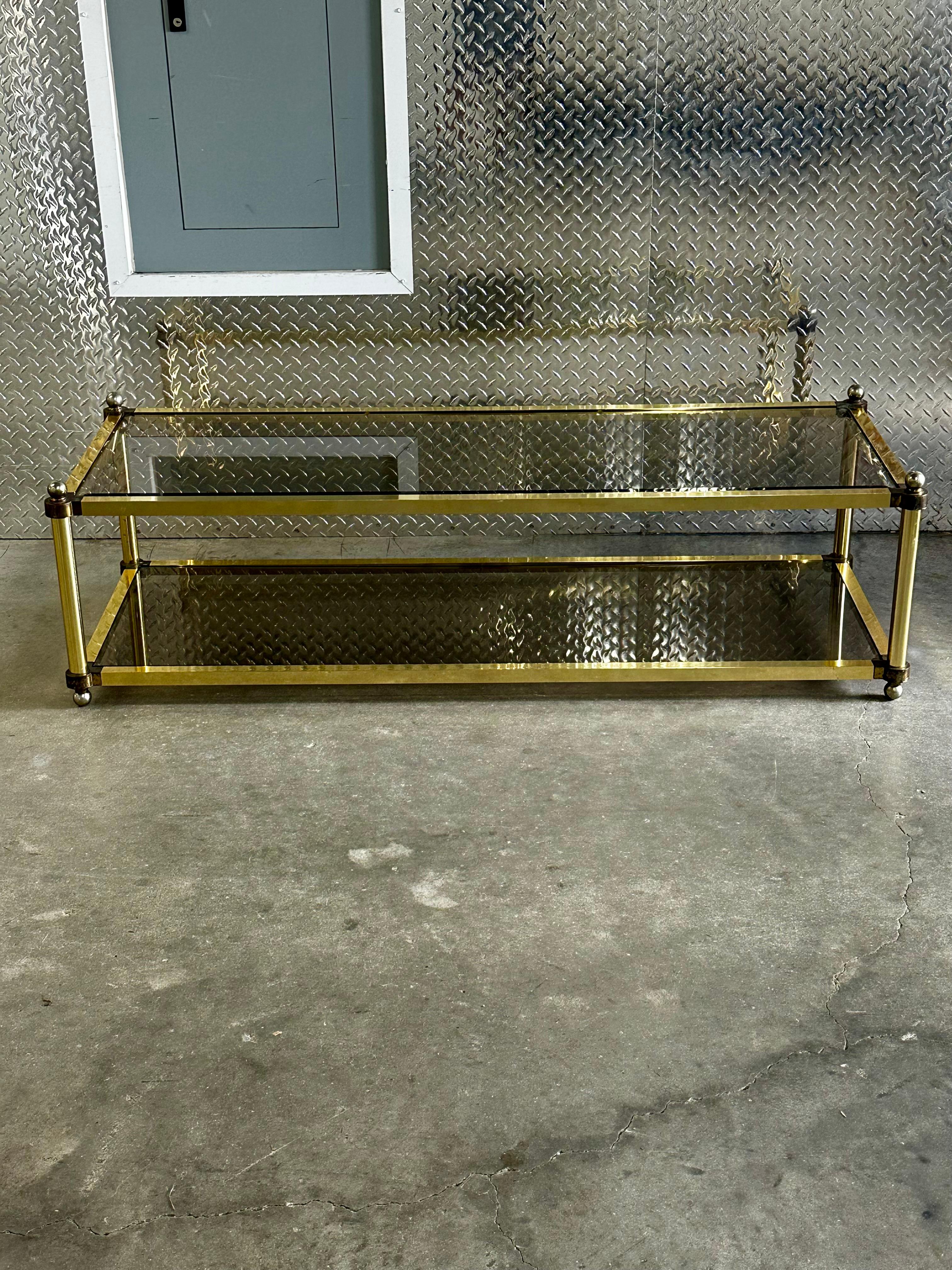 Amazing Mid-Century Modern rectangular coffee table with a brass structure and two-tiered glass tops. This fantastic piece was produced in Italy during the 1970s.  A luxurious item with a rectangular structure made of straight and clean lines with