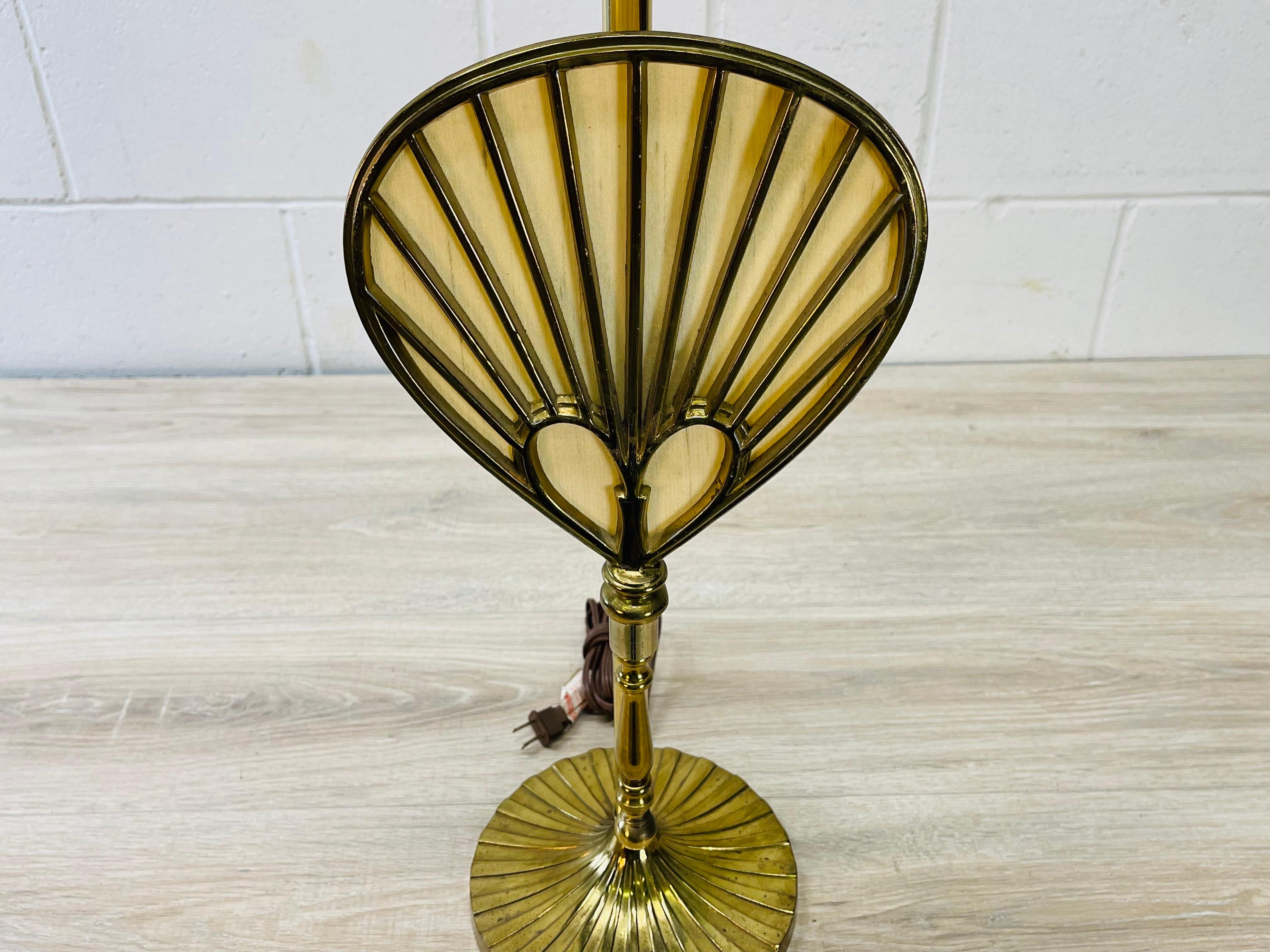 Vintage 1970s solid brass table lamp with a fan design. The lamp uses a standard 100W bulb and can also use a 3-way bulb. There is a secondary bulb behind the fan. That uses a standard chandelier bulb. Socket, 27”H. Harp, 4” Diameter x 6” Height.