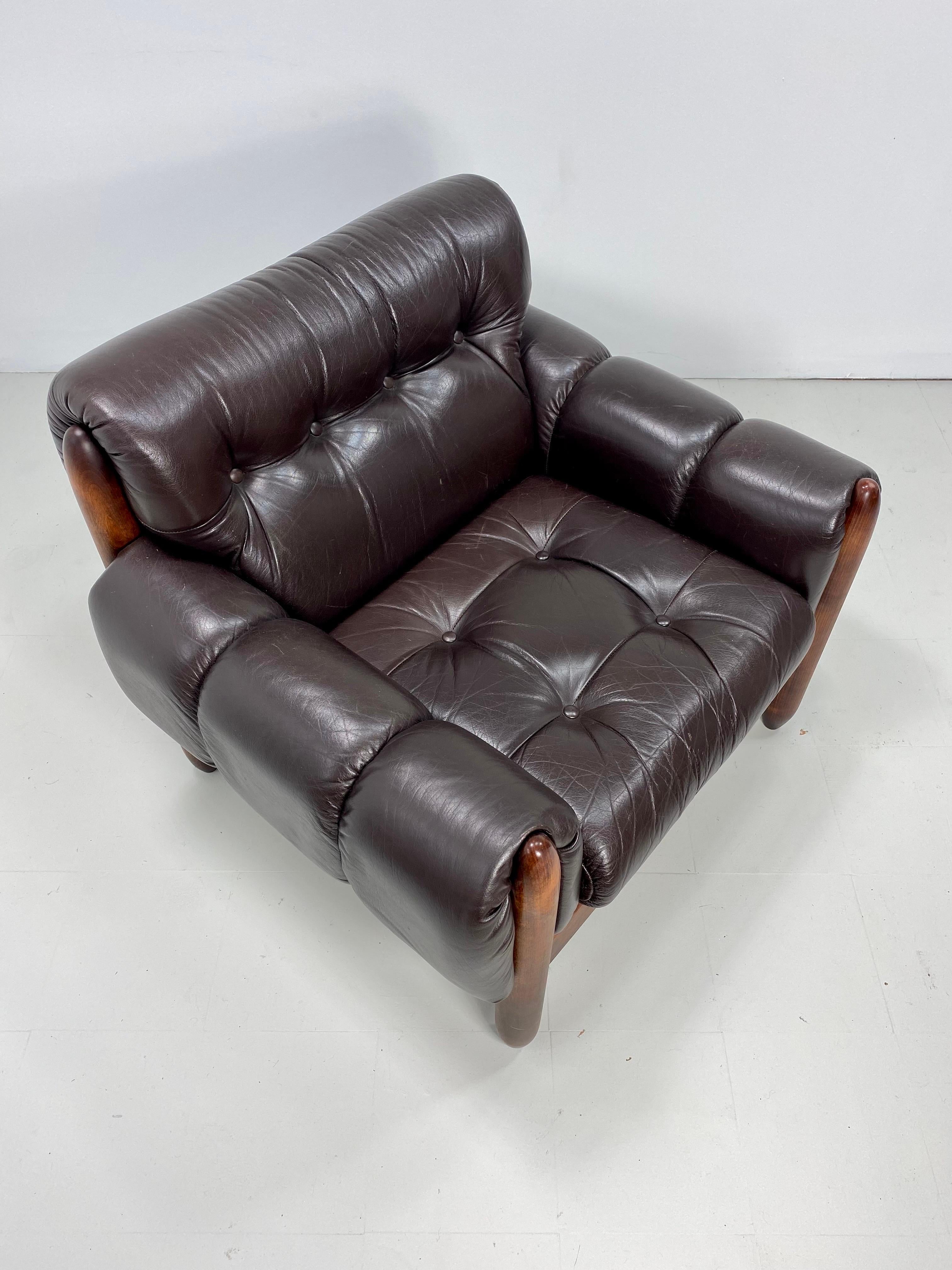 1970s Brazilian lounge chair with sculpted wood frame and button tufted leather upholstery.
