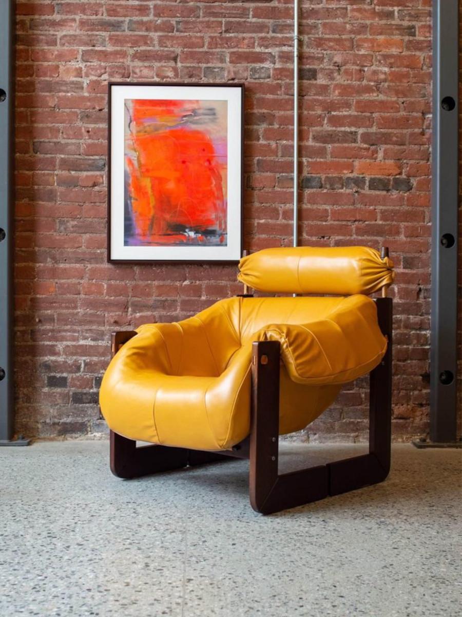 We're thrilled to present an extraordinary Brazilian lounge chair designed by Percival Lafer in the 1970s. The MP97 chair boasts a supremely comfortable foam-injected seat wrapped in leather, cleverly suspended by leather straps, all elegantly