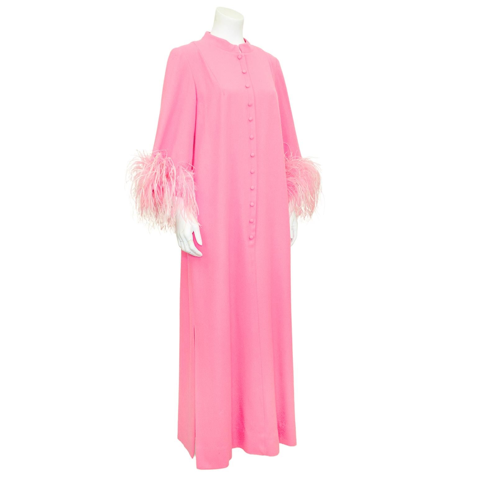 Beautiful, vibrant and fabulous hostess gown from the 1970s. Bright pink wool with pink and white ostrich feathers at the cuffs. Mandarin collar with a front zipper at centre seam that is covered by faux buttons. Floor length with a 2.5