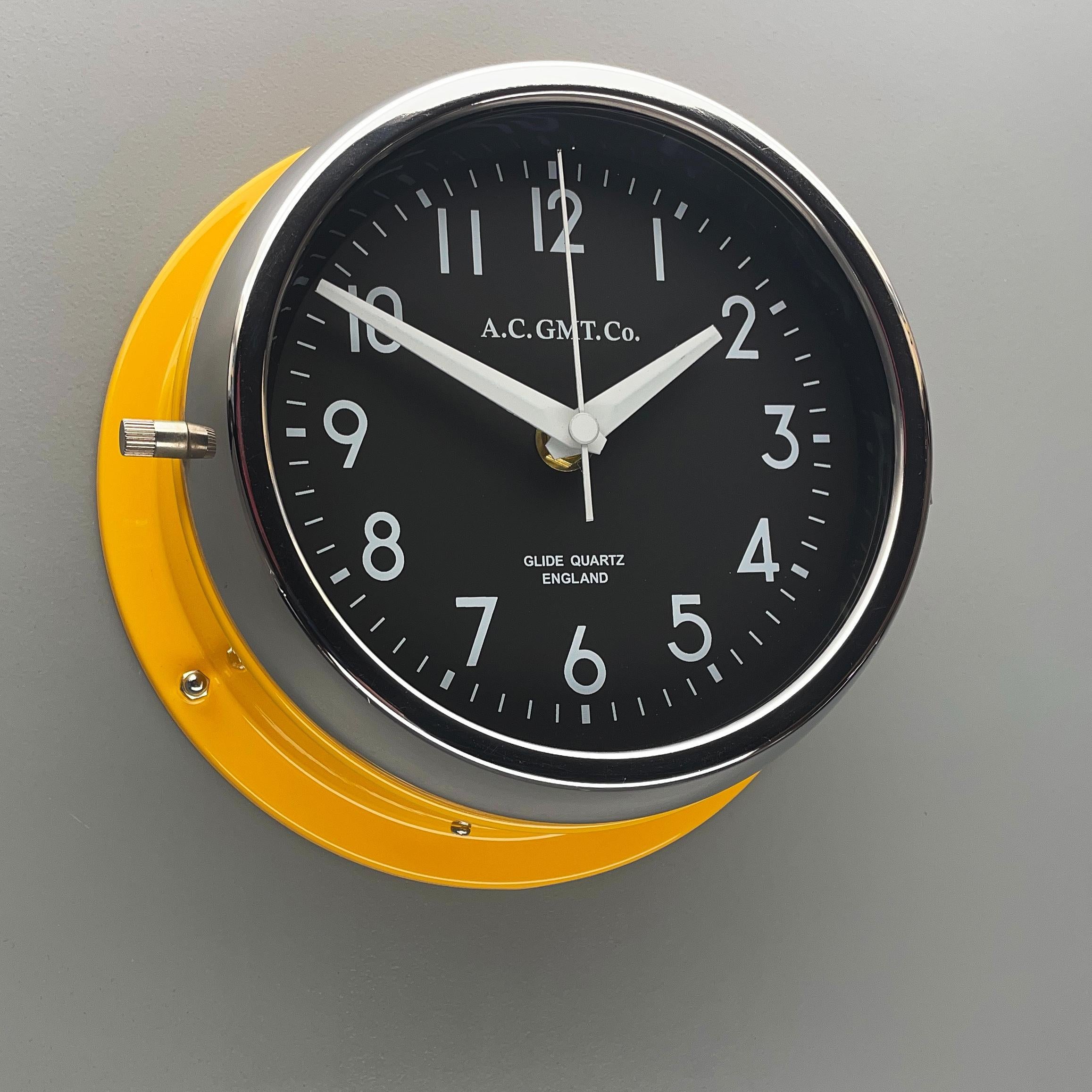 Industrial 1970s British Yellow Illumination AC GMT Co. Classic Quartz Wall Clock For Sale