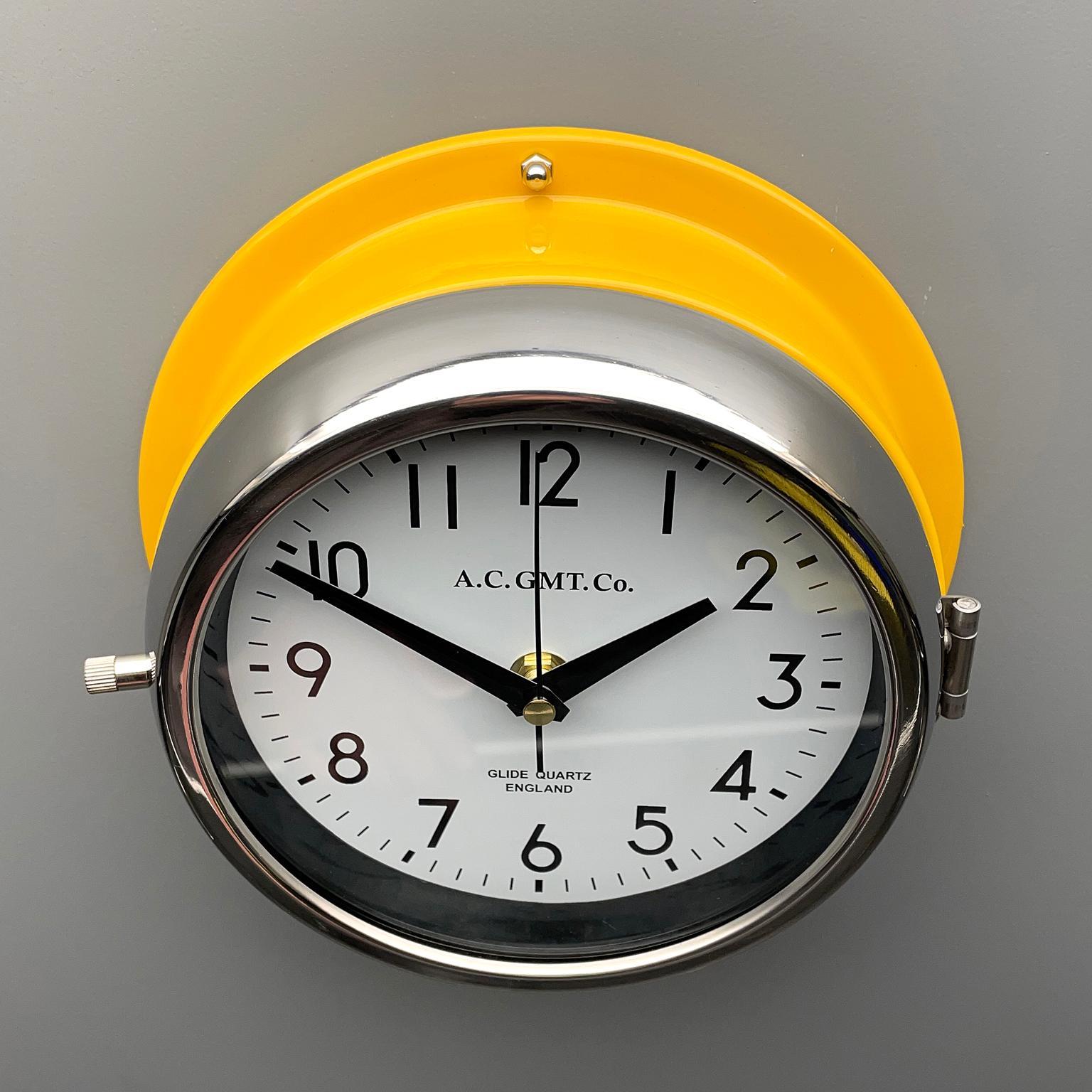 Chrome 1970's British Yellow Illumination & White AC GMT Co. Classic Quartz Wall Clock For Sale