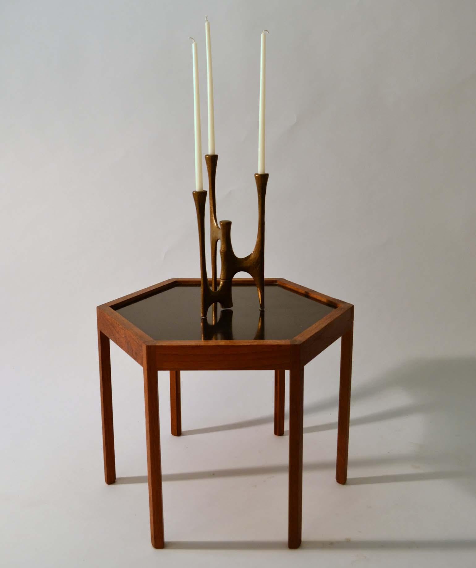 Articulated sculptural three-arm bronze candle holder with a textured patinated surface for three candles on alternating heights which pivots from a central stem. 
With the candles the total height is 55 cm.