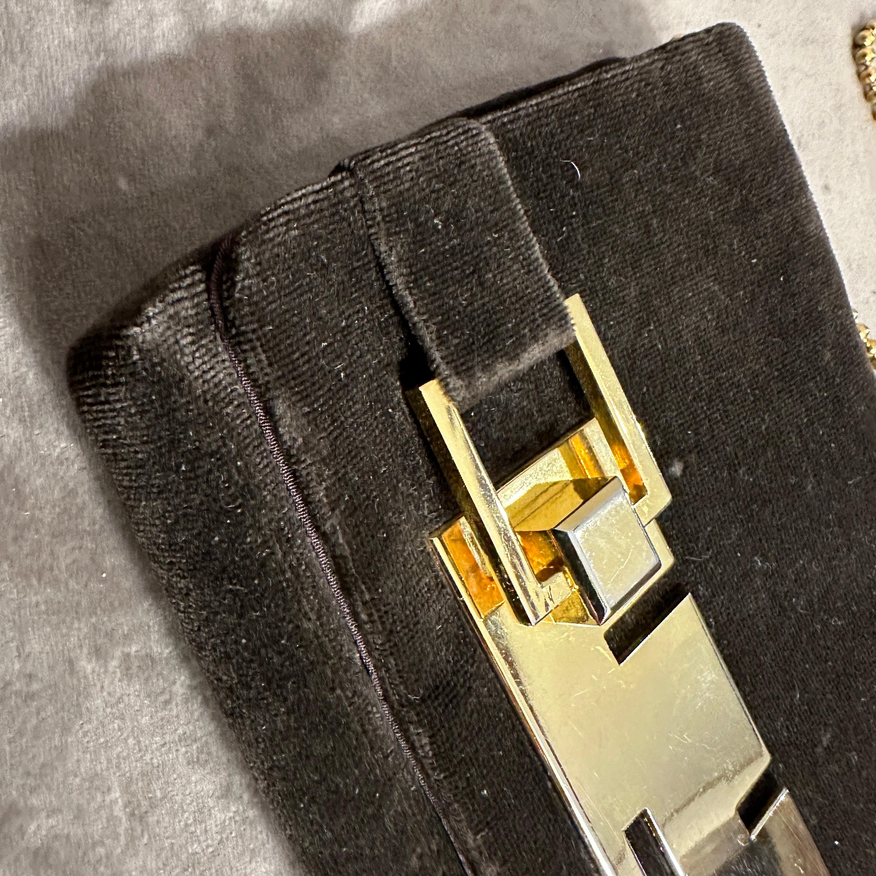 Diese Tasche besteht aus tiefbraunem Samt, der ein typisches MATERIAL des Designers war. Zur Konstruktion der Tasche gehören polierte Messingbeschläge mit Messingakzenten, die von Kunsthandwerkern hergestellt werden.  als Ergänzung zu den Taschen