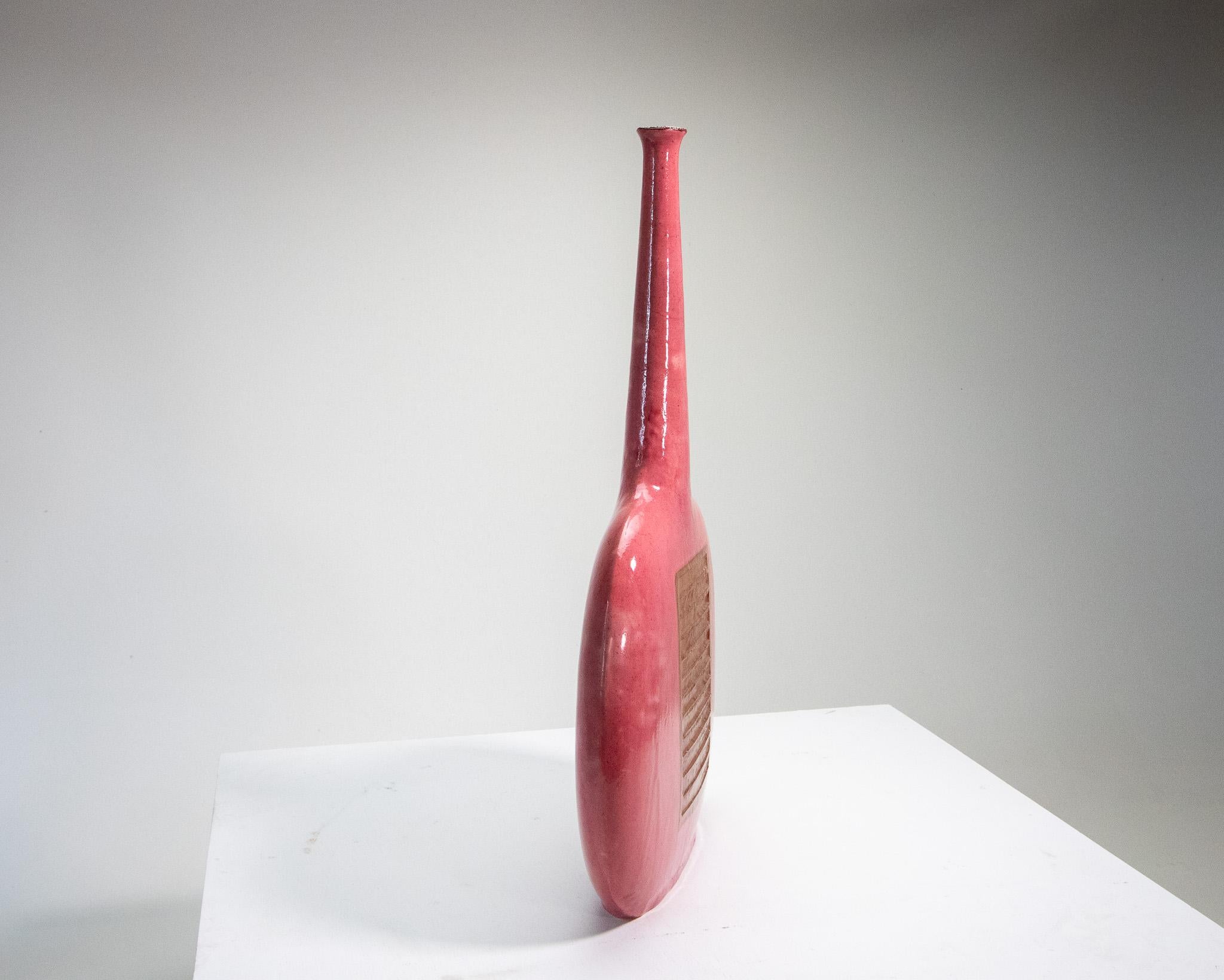 A monumental Italian ceramic vase from Bruno Gambone. C. 1970s. A rare color in hot pink with a neutral toned relief sculpted form in the middle. This is an impressive size at almost 30” tall and 17” wide. Signed Gambone Italy.

Dimensions: 29 1/8”