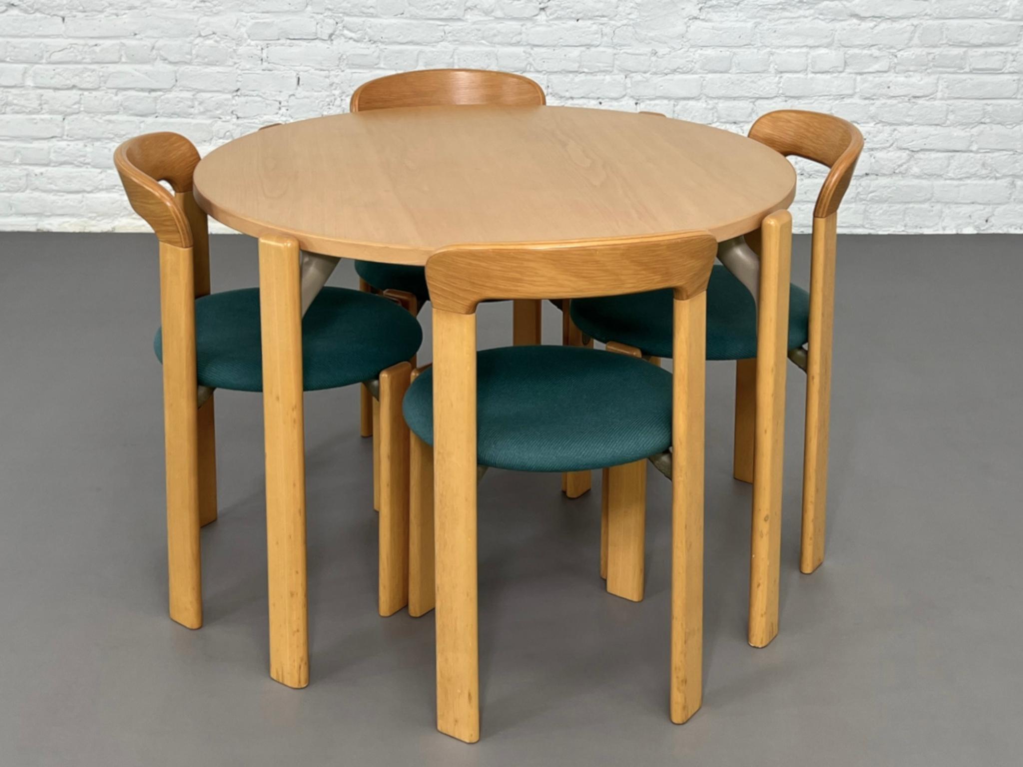 1970s Bruno Rey's Design Dining Set compose of a 107cm diameter round dining pedestal beech wood table and 4 matching chairs with a beech wooden structure and a round green fabric seat. An amasing Kusch&Co set!