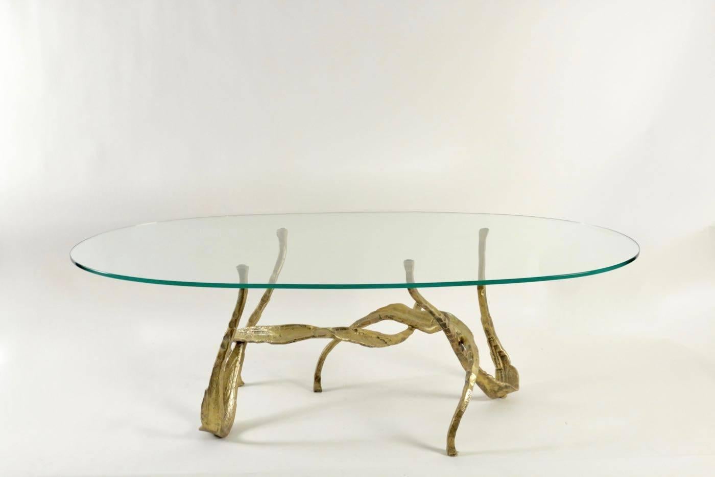 
 Sculptural and organic coffee table designed by Salvino Marsura.
 The base is made of wrought iron with a golden patina, entirely handmade by the artist.
On the top is an oval glass slab that follows the shape of the base.   

Engraved signature