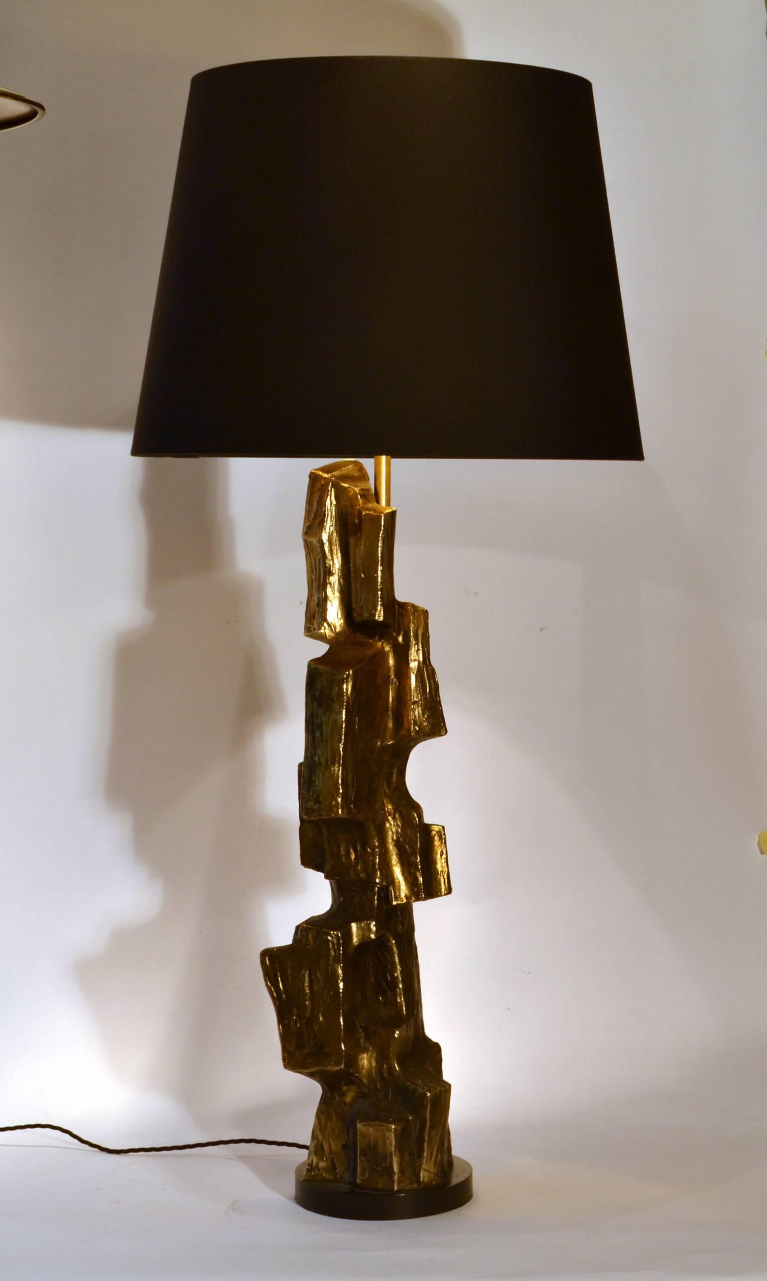Tall sculptural lamp base finished in bronze patina over textural cast metal body. Base is wood finished in satin black lacquer. Brutalist table lamp designed by Maurizio Tempestini for Laurel Lamp Company, 1970s.
The lamp comes with an ivory silk