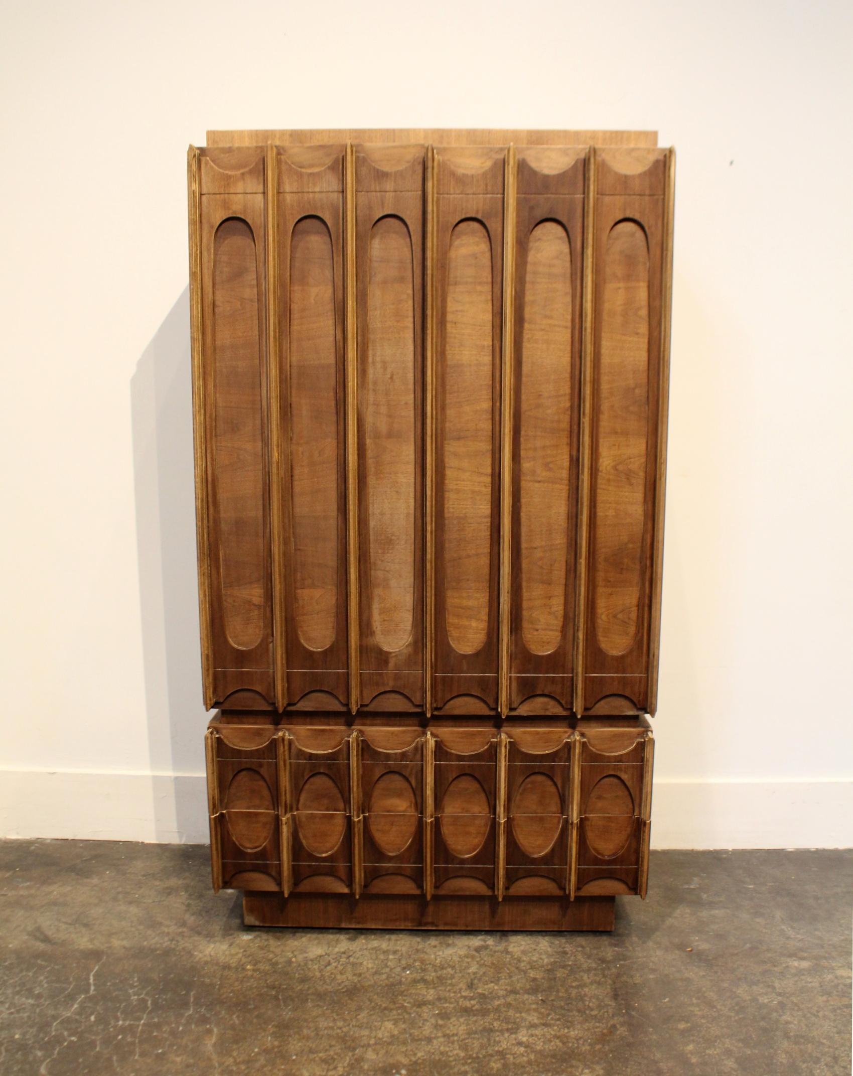 One of a kind Brutalist 1970s two-piece wardrobe; stripped down to its natural walnut wood and refinished with a flat protective finish. Strong sculptural, Brasilia-style front and stunning natural patina. Six feet in height with spacious drawer and