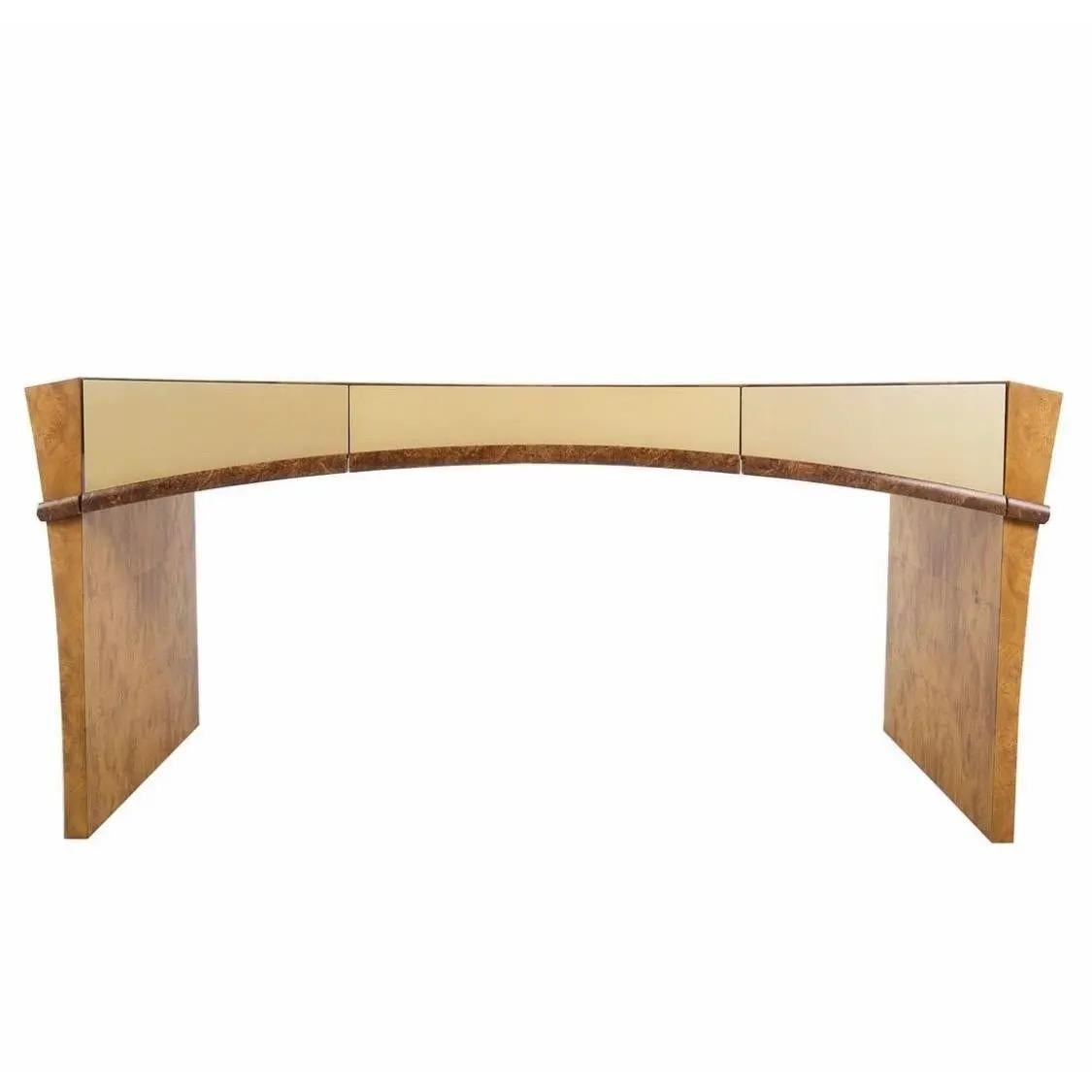This executive desk from the 1970s is a stunning piece of furniture, boasting a gorgeous burl veneer with a lacquered finish. The beautiful and spacial top of the desk features three drawers, including a central long drawer and two shorter ones on
