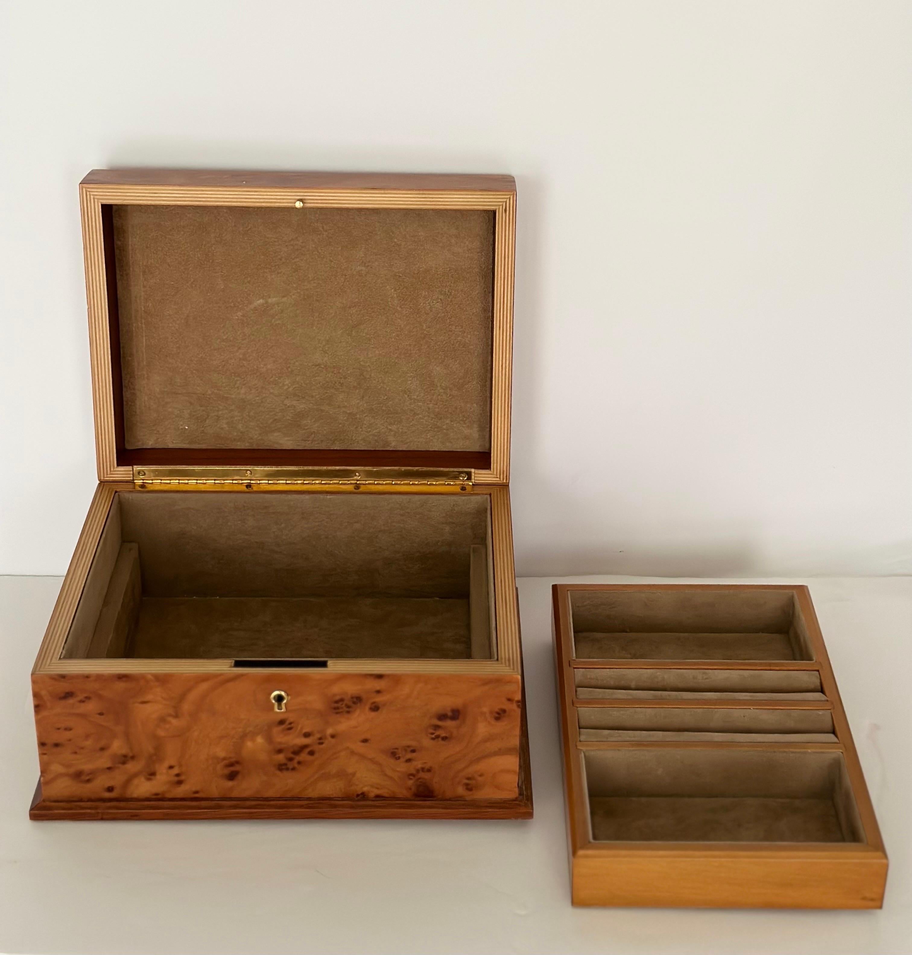 We are very pleased to offer a delightful burlwood jewelry box, circa the 1970s.  Crafted with care, it serves as both a functional storage solution and a visually appealing piece.  As you lift the lid, you'll discover a well-designed interior that