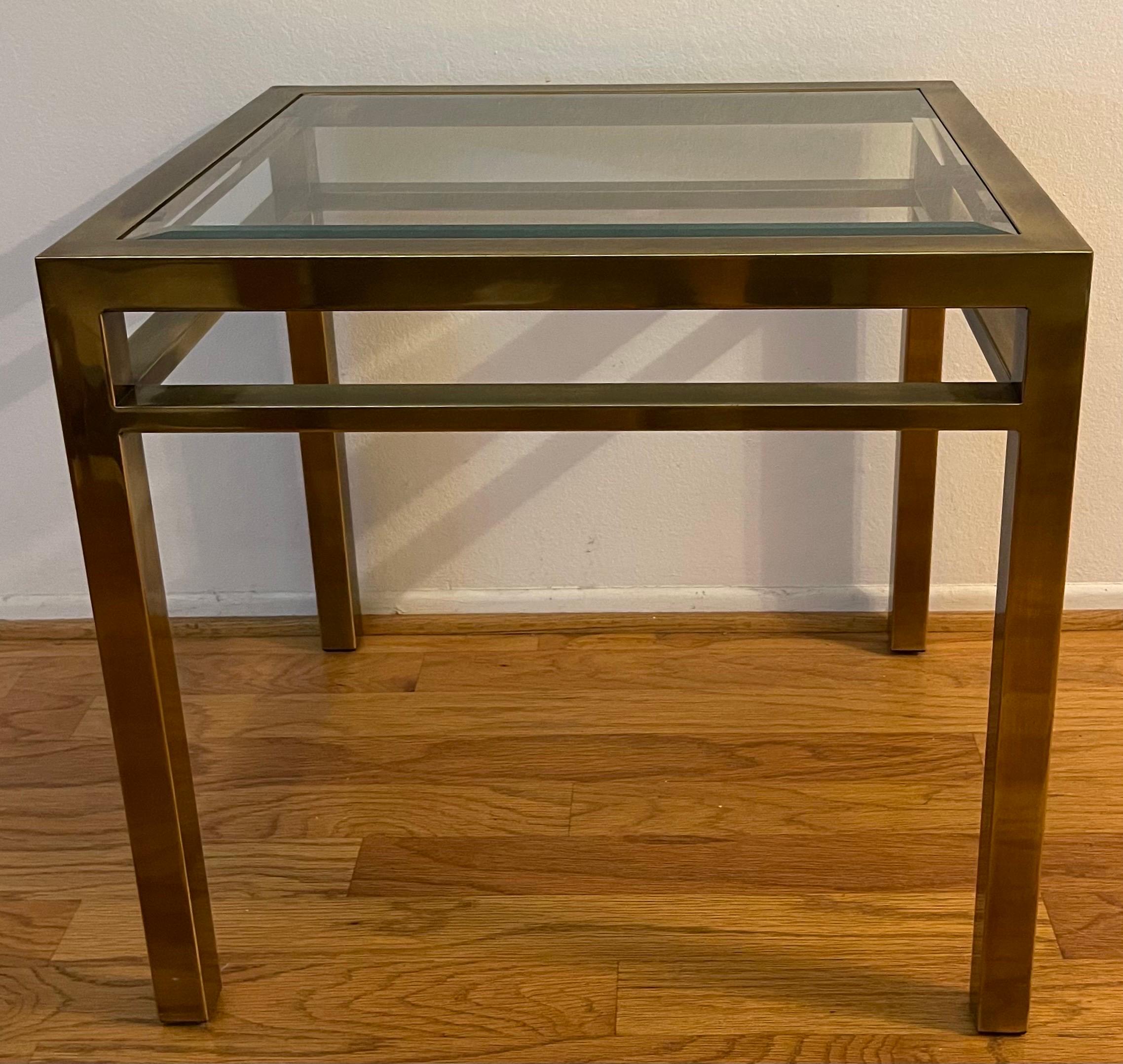 1970s burnished brass side table or end table in the style of Mastercraft. Original clear beveled glass top. 