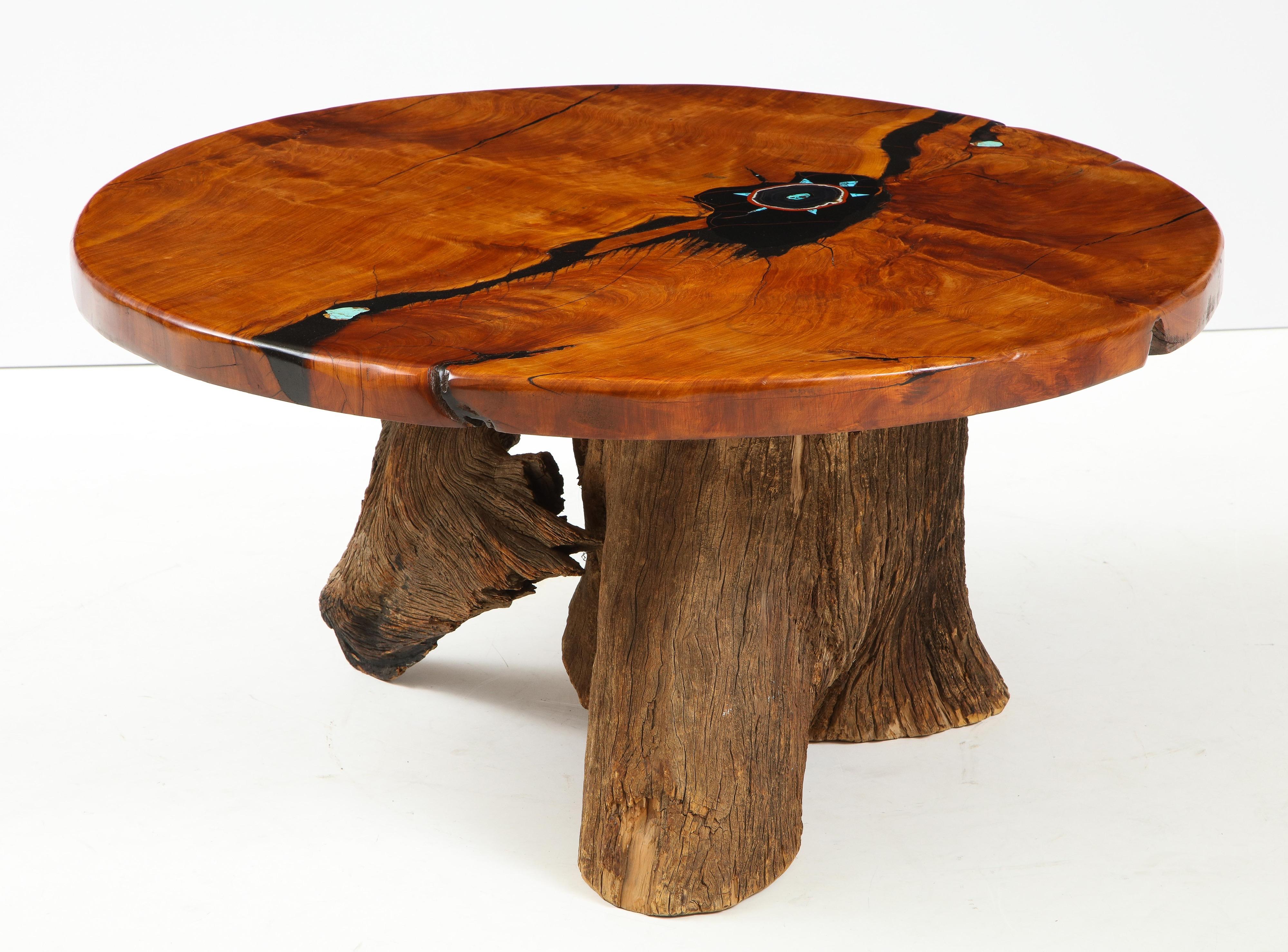 A unique hand crafted polished wood top with black resin inlay and turquoise stones. The top is able to rotate, Lazy Susan style. The base is a natural driftwood trunk.