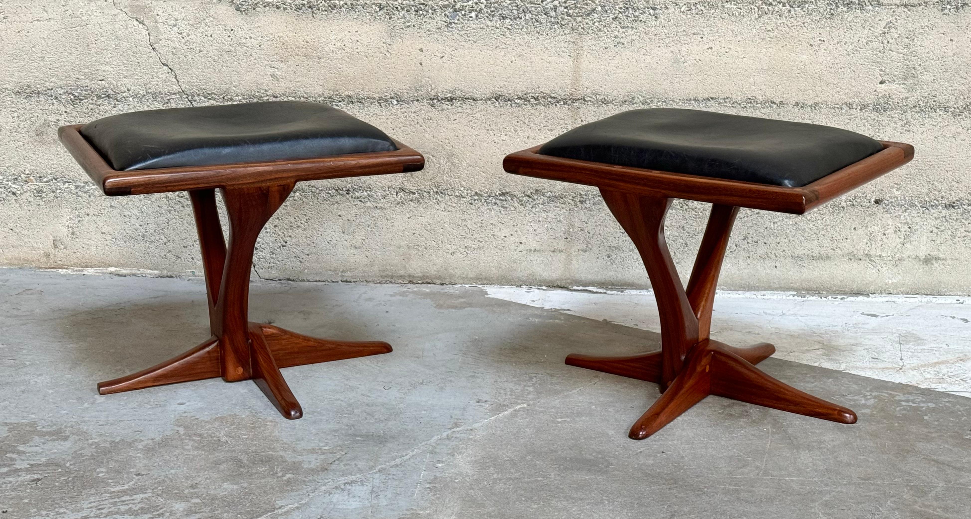 1970s walnut and leather studio wood stools with a V shaped frame with flowing down to a four legged asymmetrical base. The influences of the design can be found in nature with blends of both plant and marine life. Signed Guido 71.