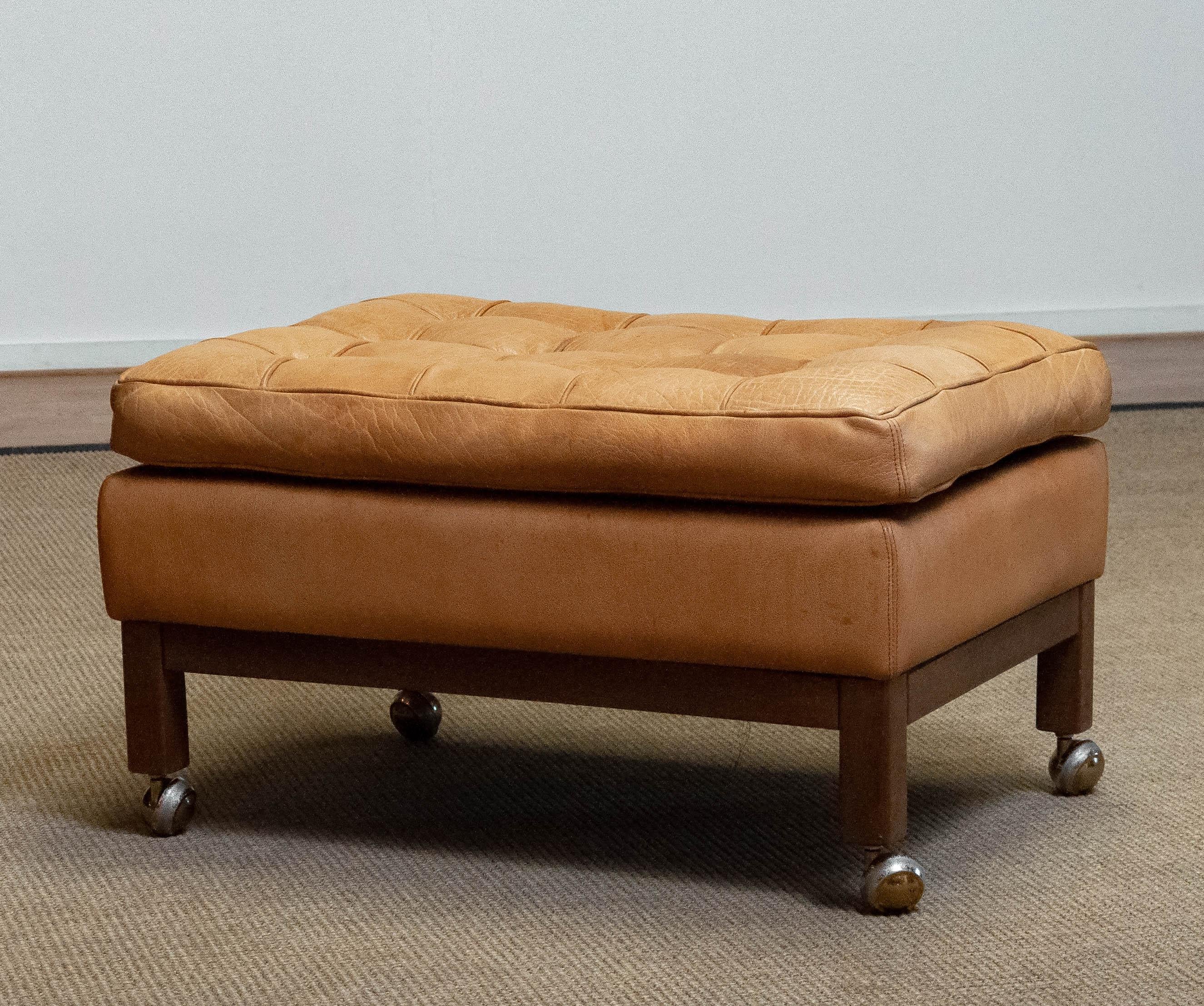 Square ottoman in sturdy camel / brown colored leather designed by Arne Norell for Norell AB in Sweden. The brown wooden frame is made of Oak. Allover in good condition.

Please note!
Because Shipping Costs highly fluctuate daily, we kindly ask you