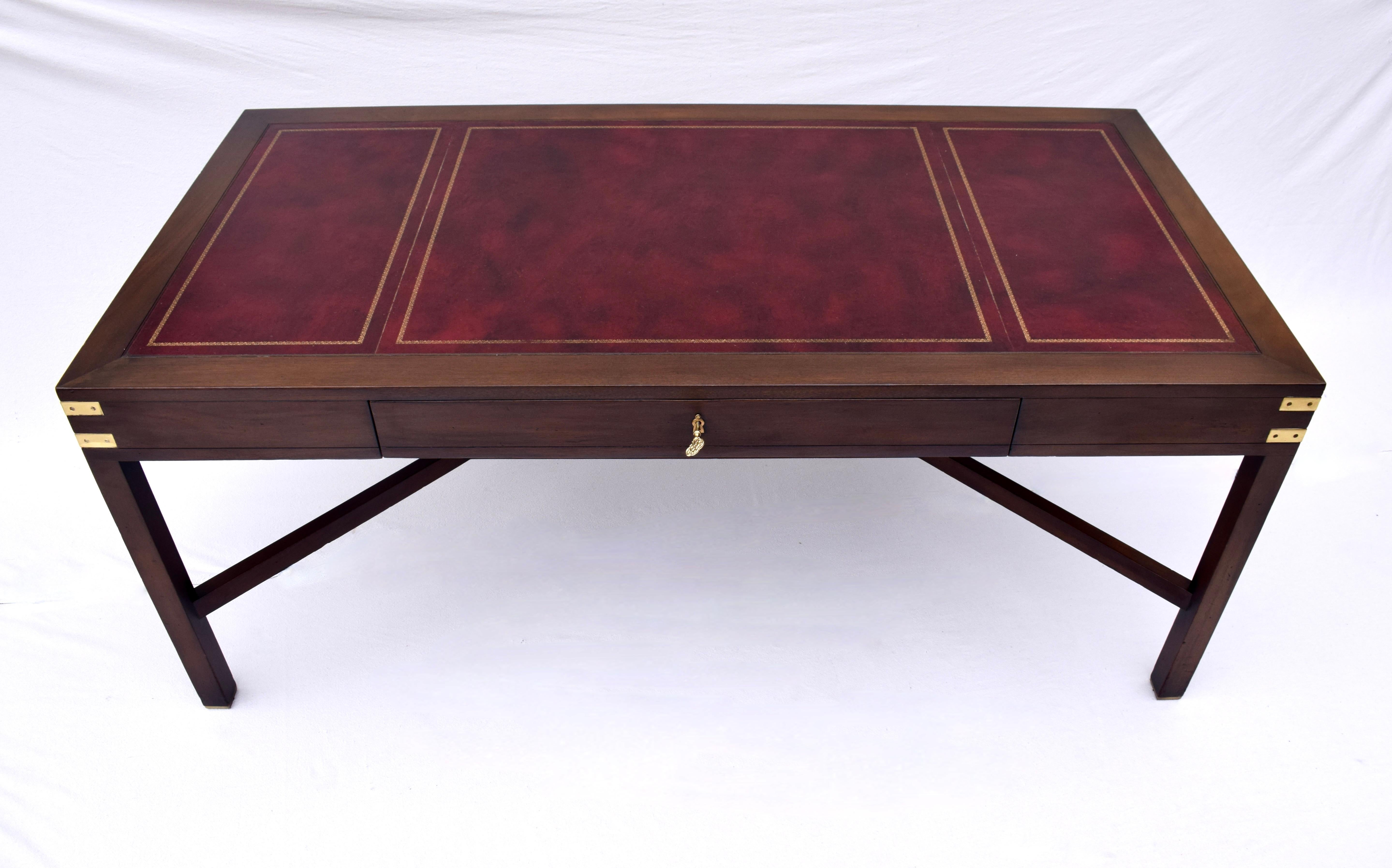 A limited edition walnut desk by Alex Stuart Designs in the Campaign style with tooled leather top, generous writing surface & a single felt lined drawer. Gorgeous lithe lines embellished with polished brass hardware, the desk is signed & numbered &